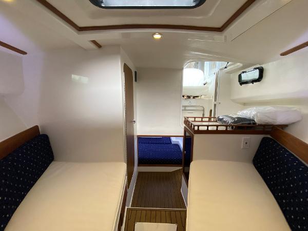 Interior of the 2015 Eastern 27 Islander with two benches and wooden flooring.