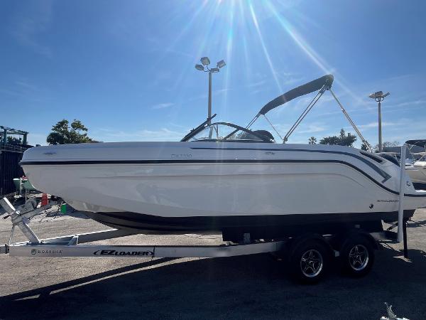 2021 Bayliner DX 2200 boat on trailer under bright sunlight.