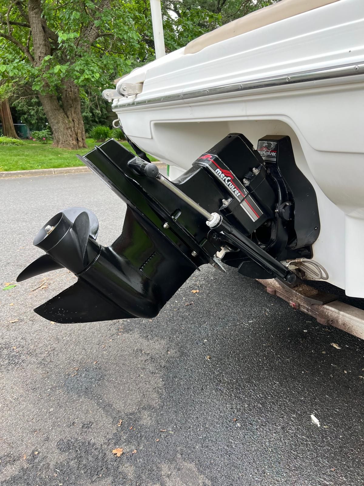 A 1997 Sea Ray 190 Bow Rider with a black outboard motor, parked on a street.