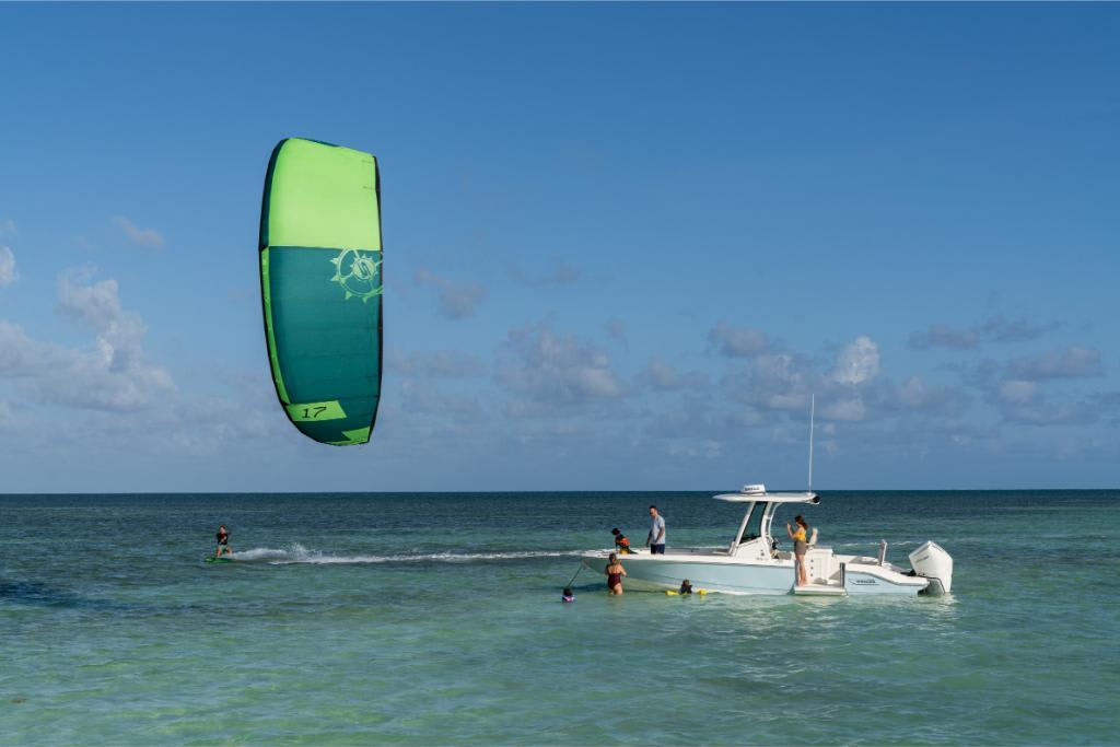 2024 Boston Whaler 280 Dauntless with people enjoying water activities and kite surfing.