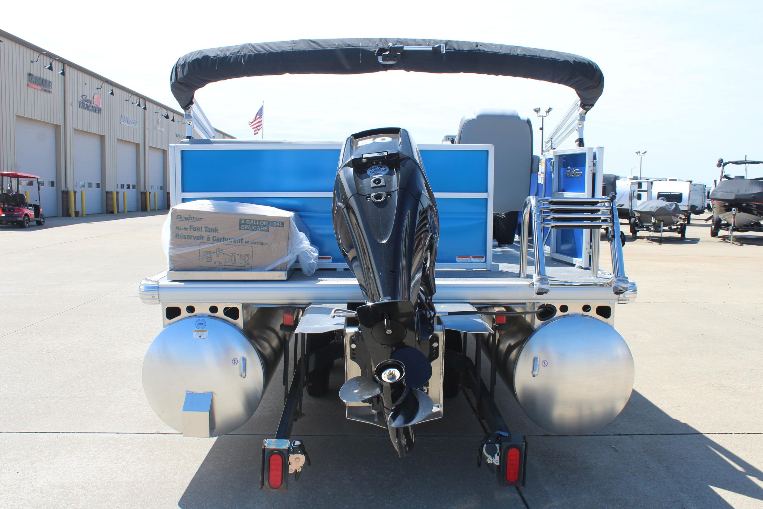 2026 Sun Tracker Party Barge 16 DLX pontoon boat with outboard motor, docked outdoors.