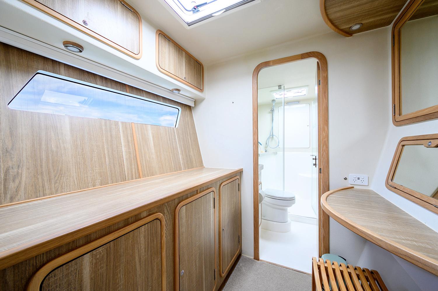 Interior of 2019 Knysna 500SE yacht with wooden cabinetry and bathroom view.