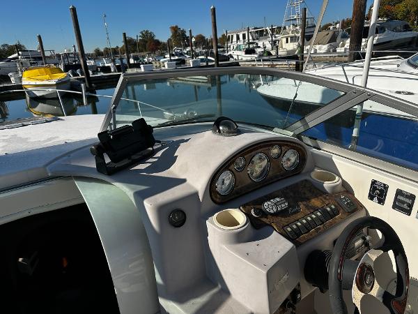 2004 Rinker Fiesta Vee 250 boat dashboard at marina, showcasing controls and gauges.