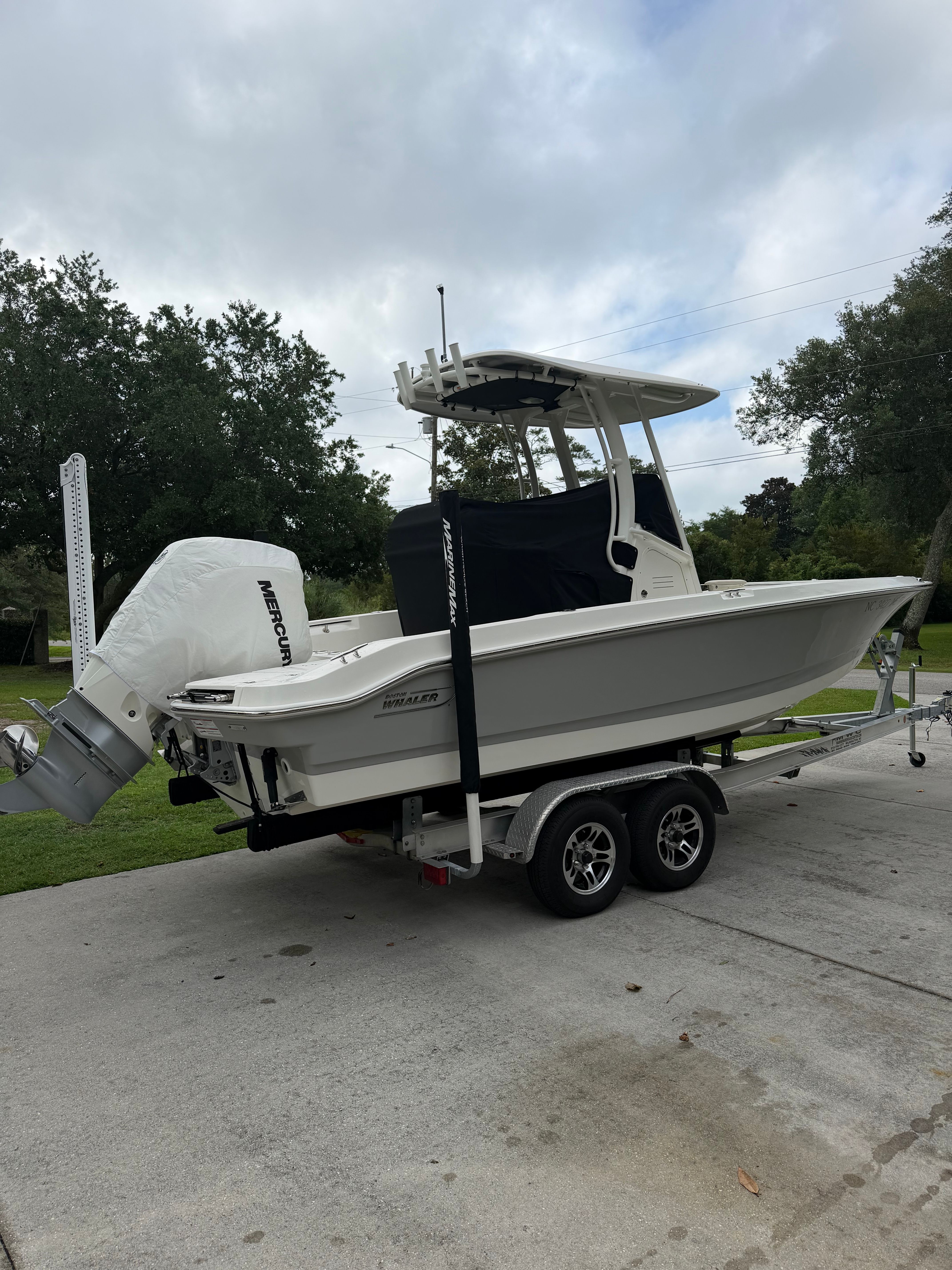 A 2025 Boston Whaler 220 Dauntless on a trailer, featuring a Mercury outboard motor.