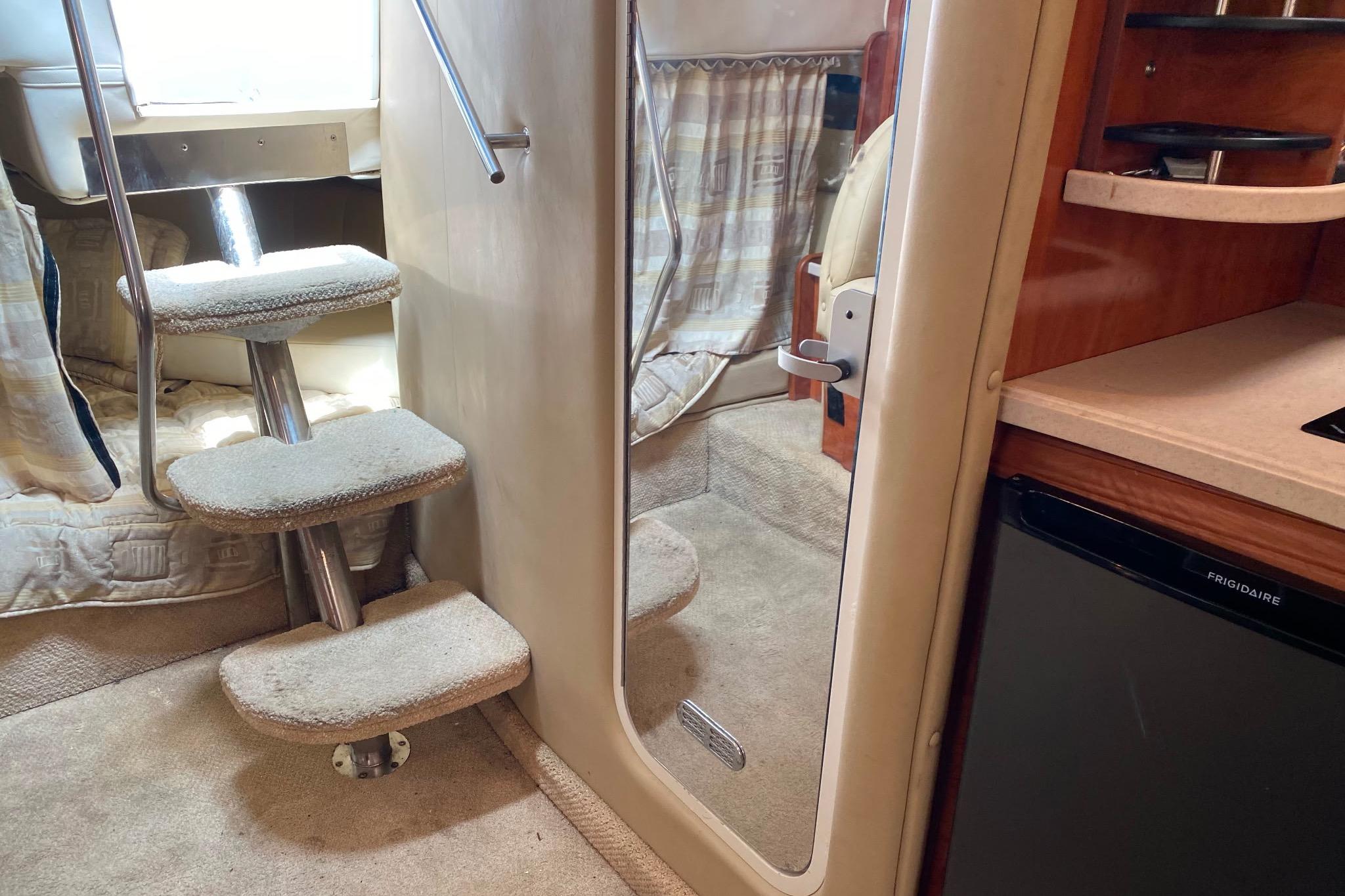 Interior of 2003 Rinker Fiesta Vee 342 boat with carpeted stairs and kitchenette.