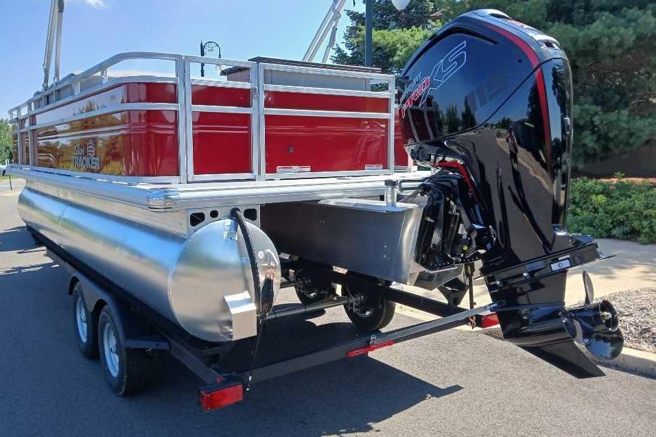 2026 Sun Tracker SportFish 20 DLX pontoon boat with powerful outboard motor on trailer.