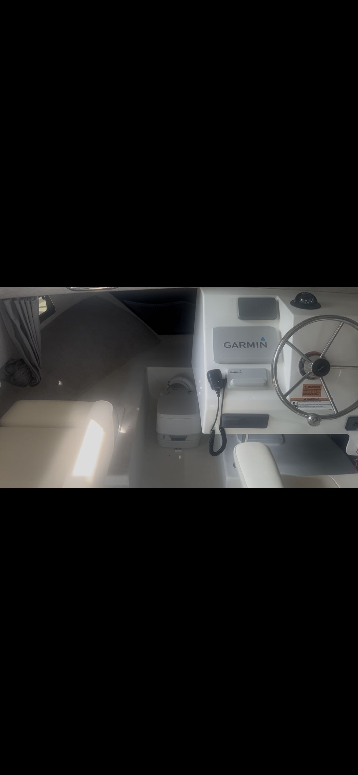 Interior view of a Parker 2320 Sport Cabin with steering wheel and Garmin device.