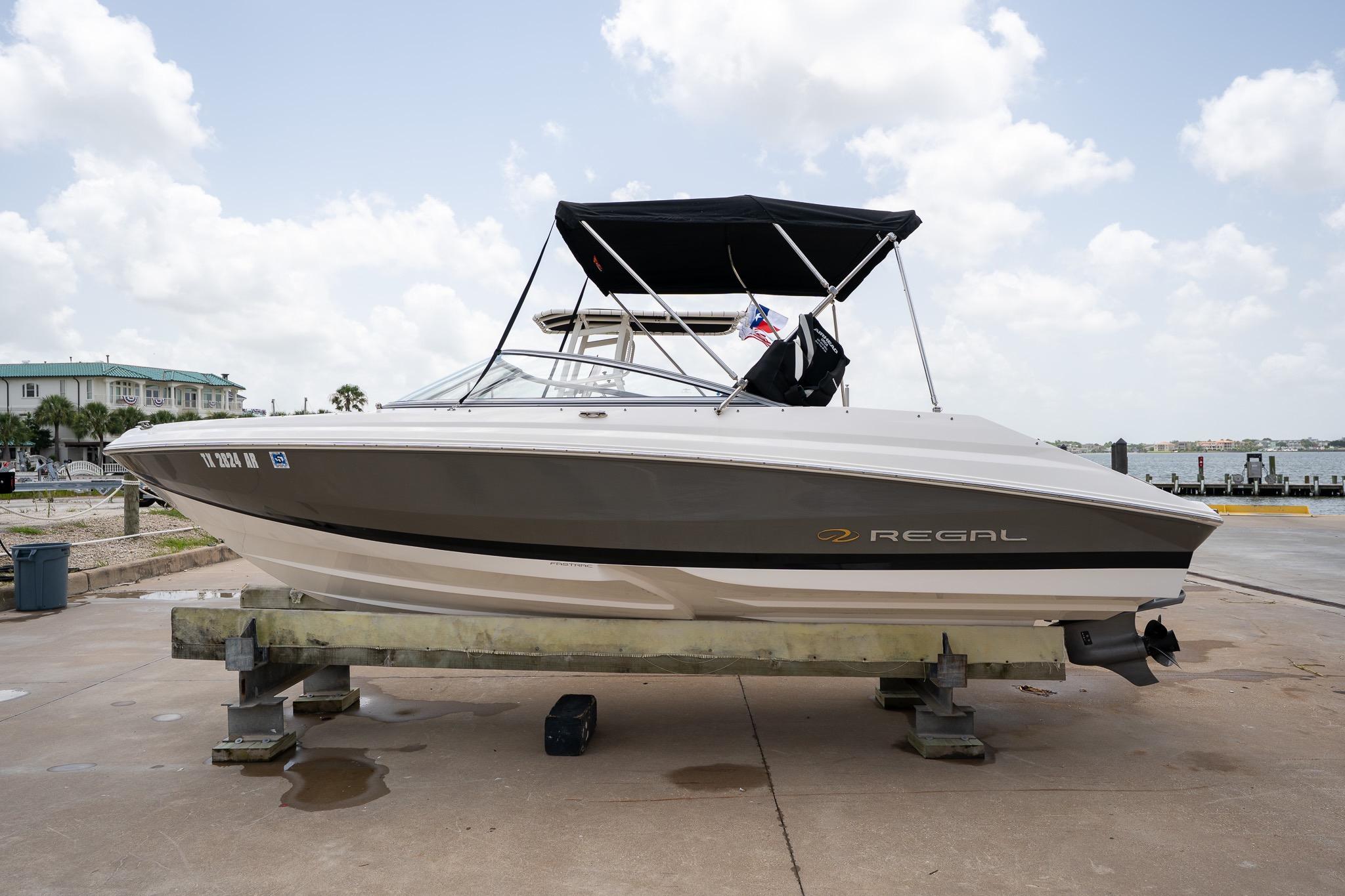 2008 Regal 2000 Bowrider boat on a dock, featuring sleek design and canopy.