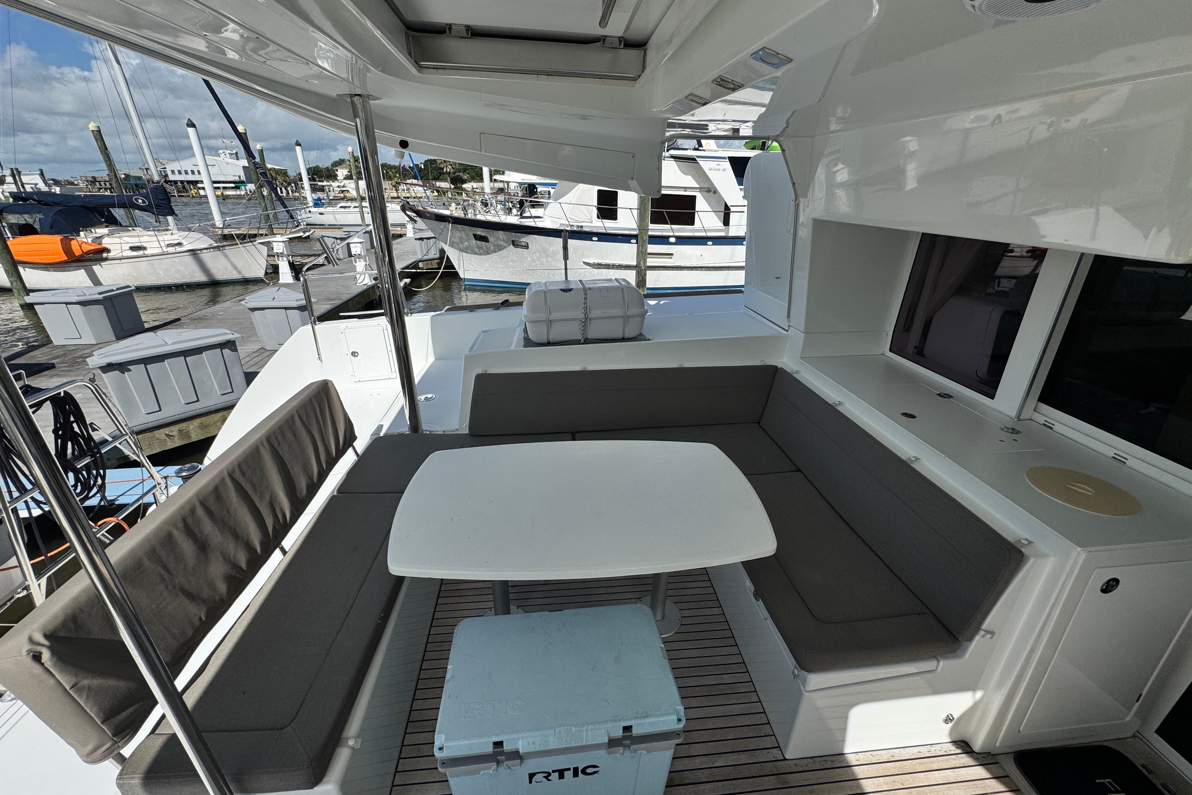 2016 Lagoon 450 yacht deck with seating area and table at marina.