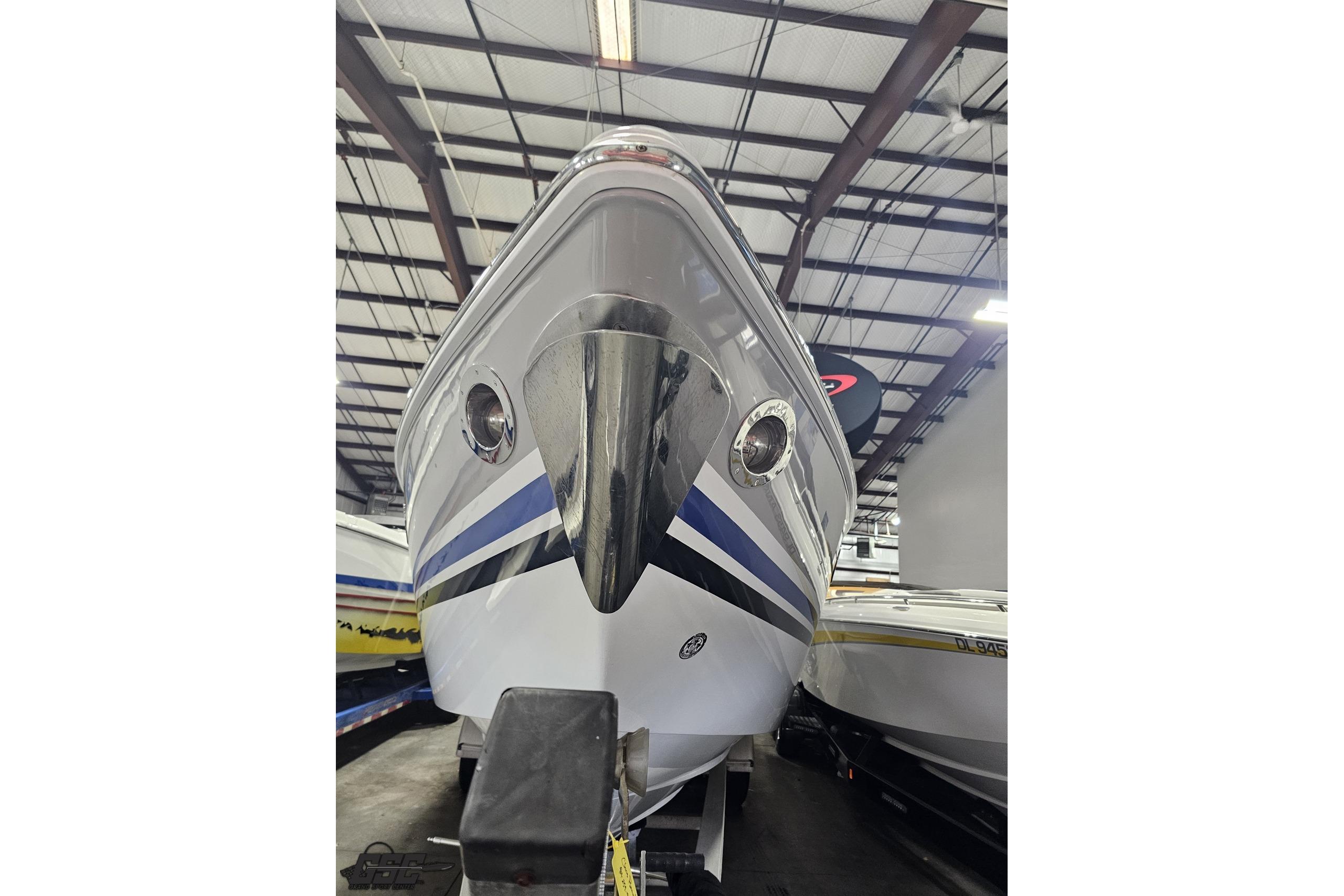 2008 Baja 335 Performance boat in storage, showcasing sleek design and vibrant stripes.