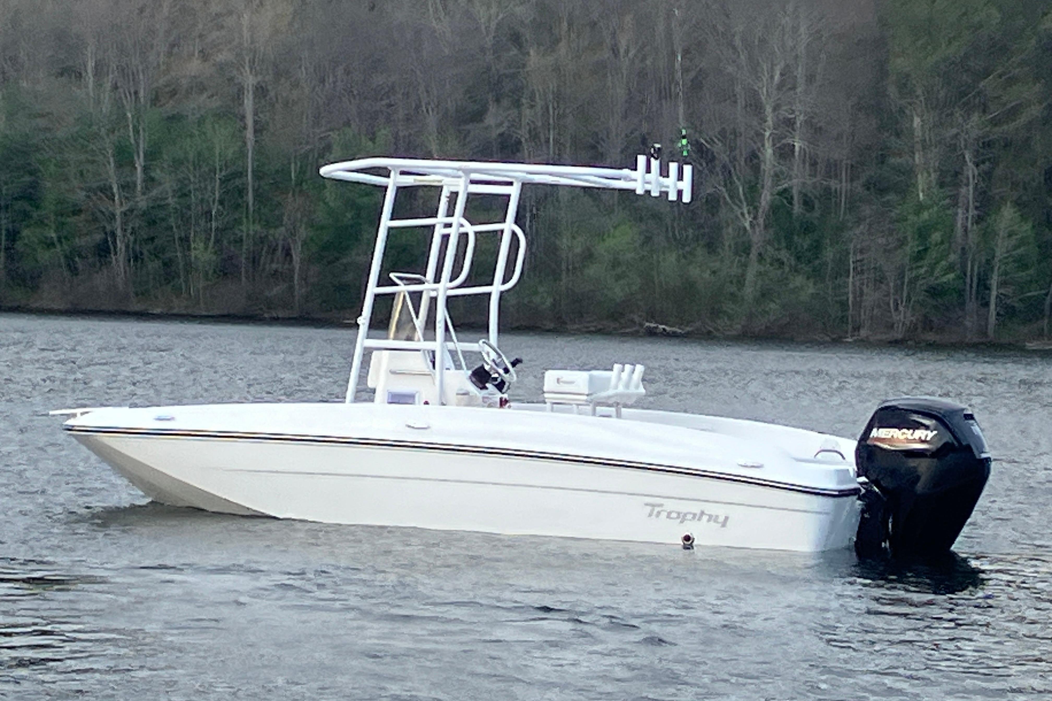 2026 Bayliner Trophy T18 boat on a calm lake with forested background.