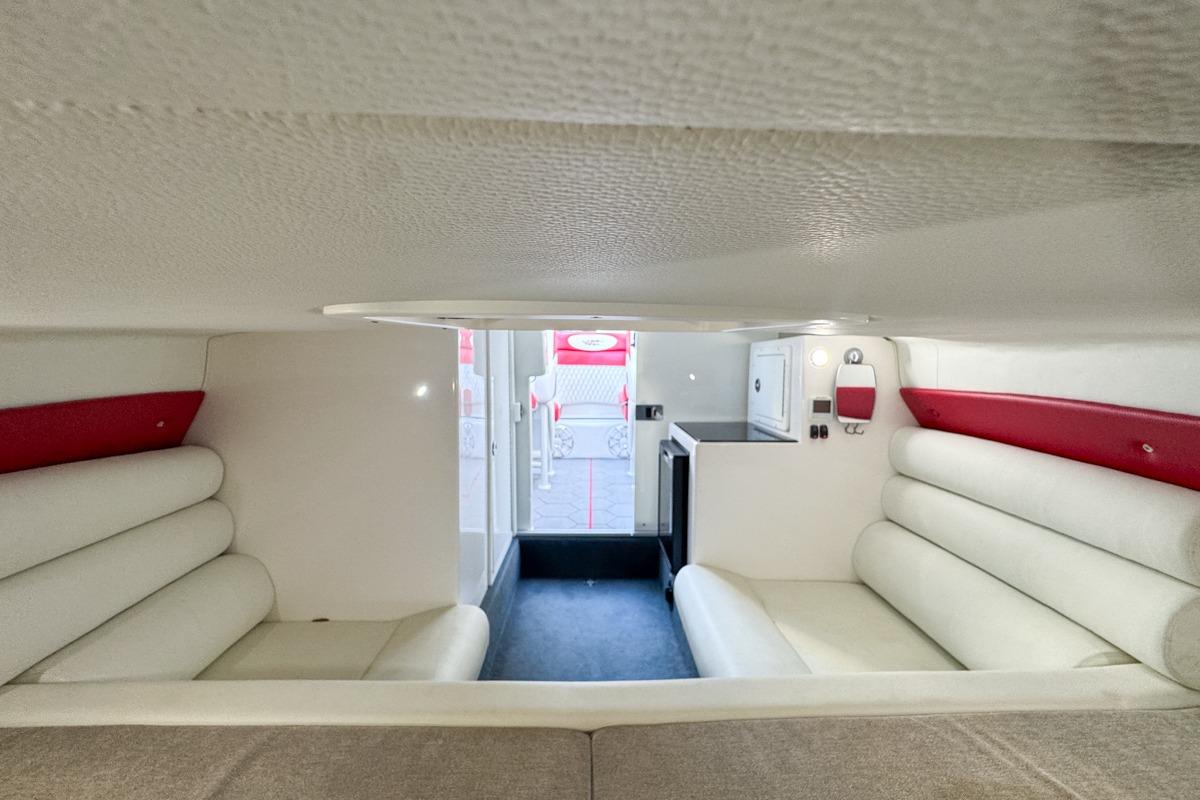 Interior of 2022 Velocity 290sc boat with white and red seating, compact design.