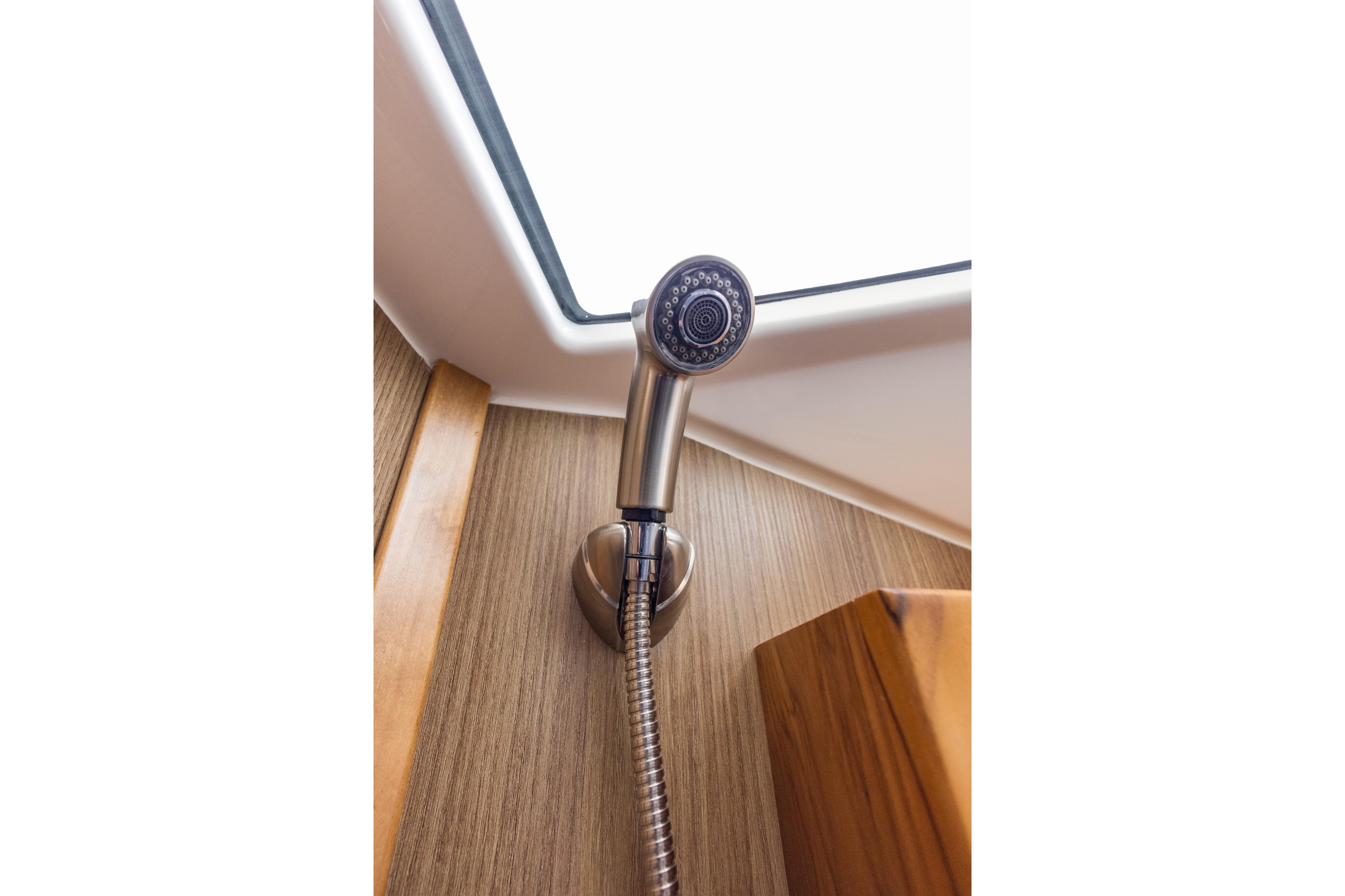 Showerhead in Solara S-310 CW yacht bathroom, 2025 model, with wood paneling and skylight.