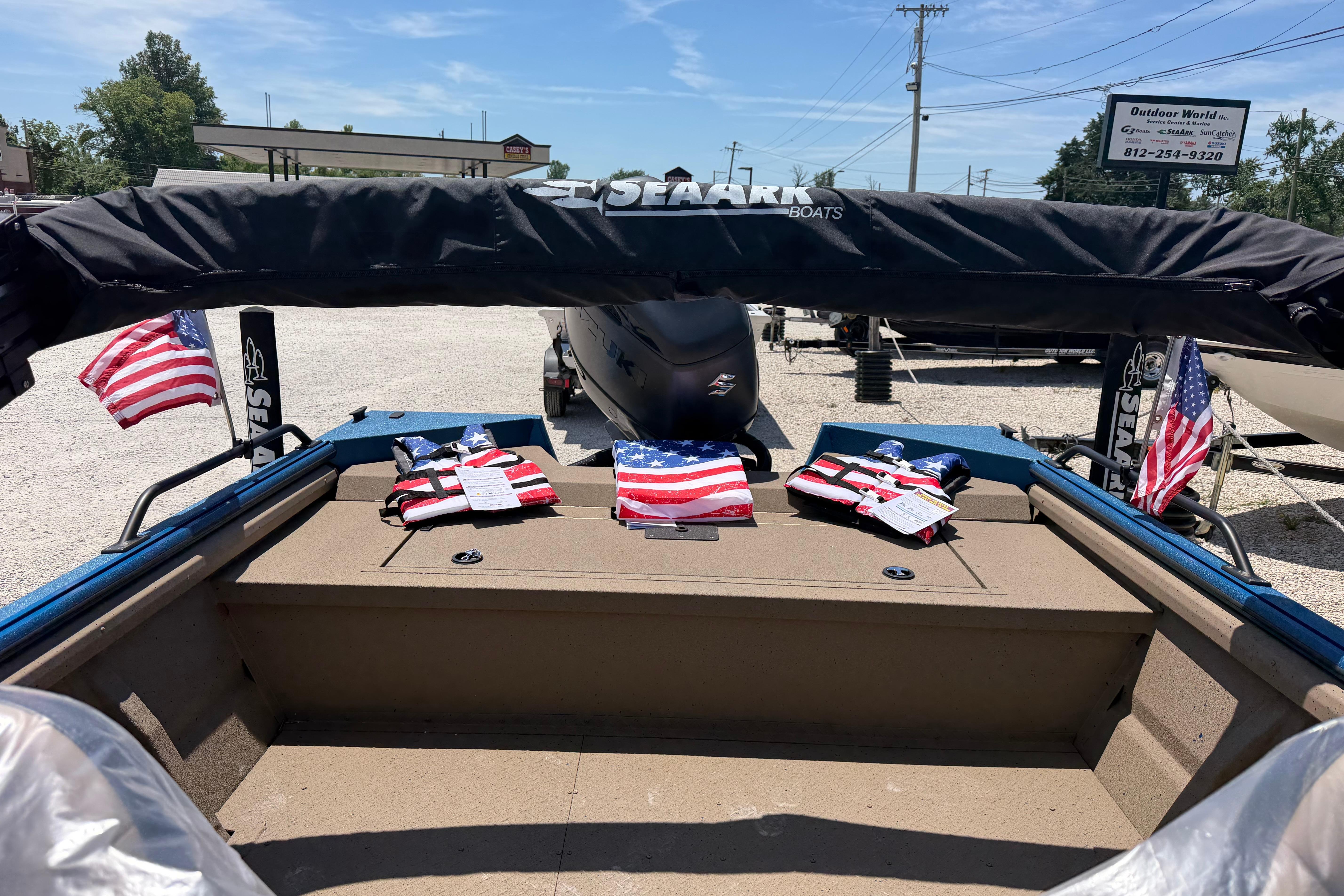2025 SeaArk Protege 240 boat with American flags and life jackets on display.