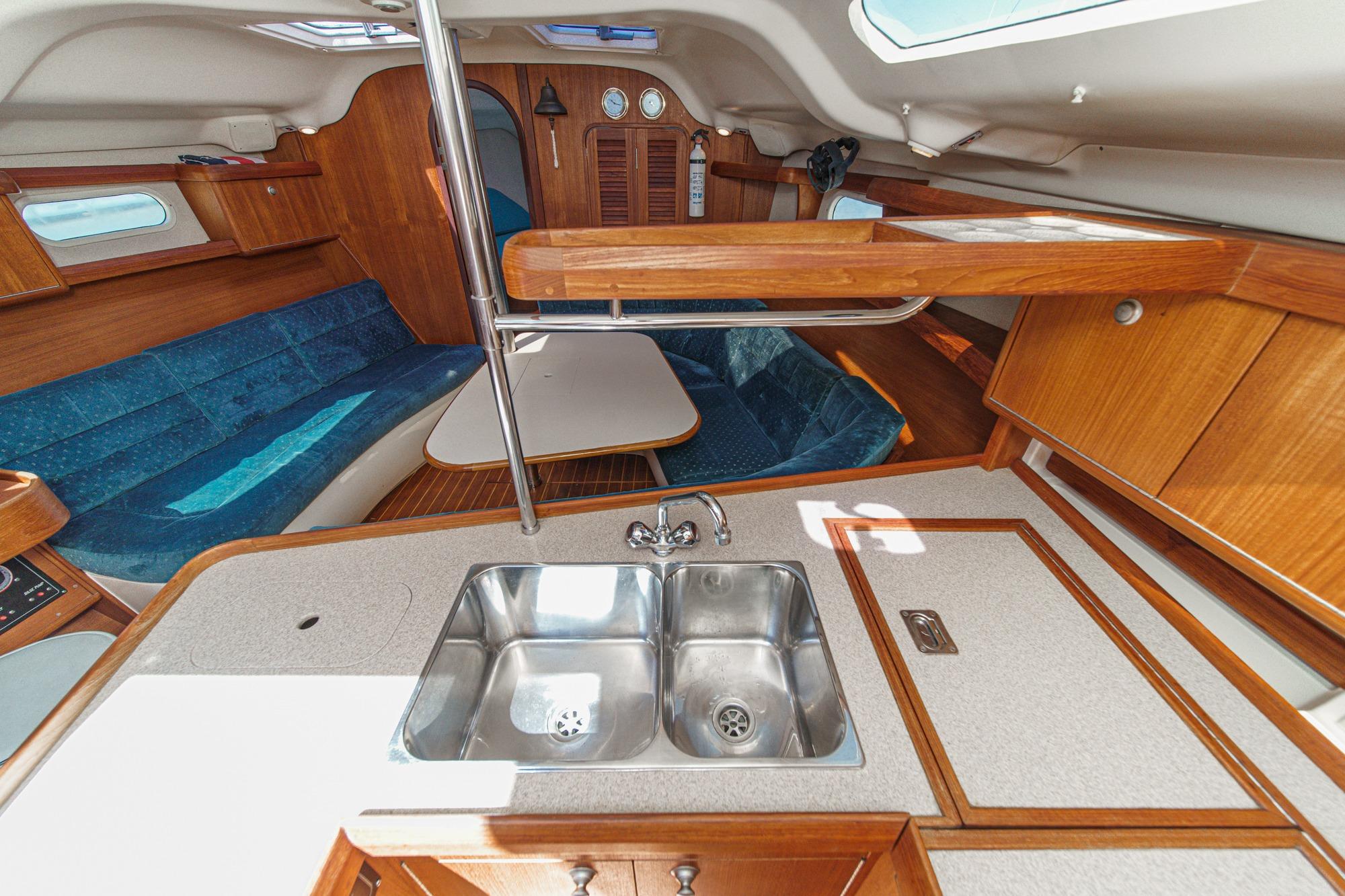 Interior of a 1996 Hunter 376 sailboat featuring a compact kitchen and seating area.