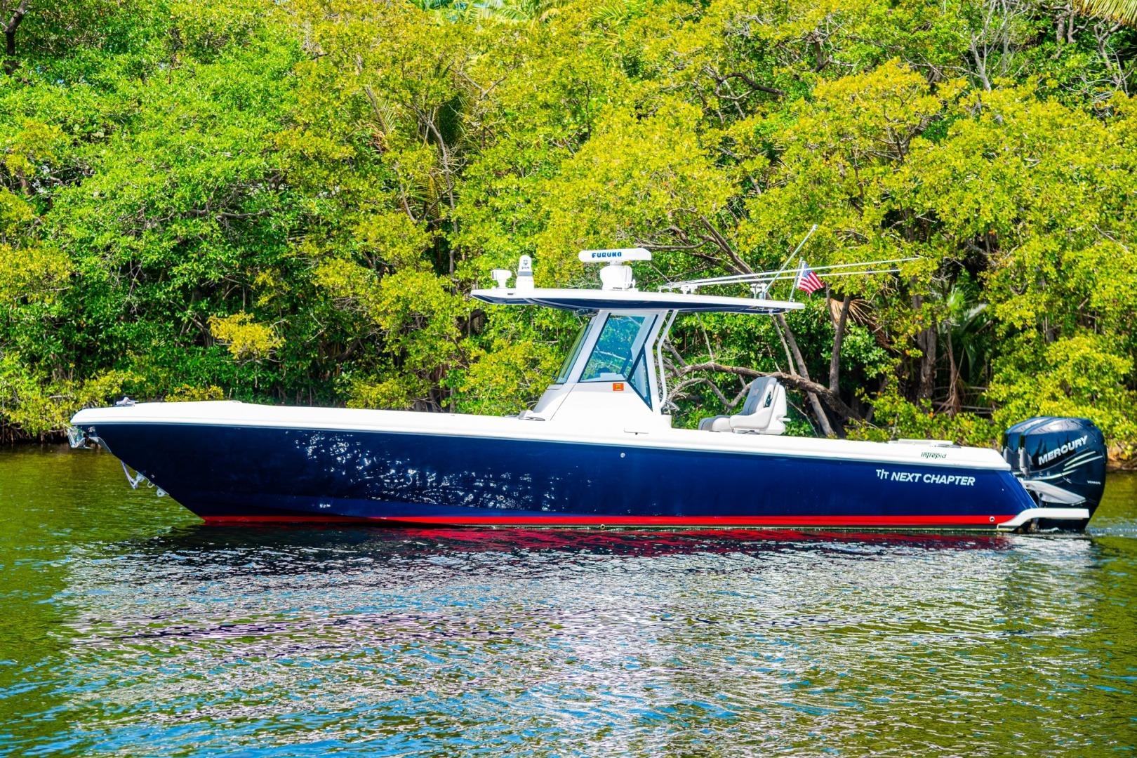 2018 Intrepid 327 Center Console boat on water, surrounded by lush greenery.
