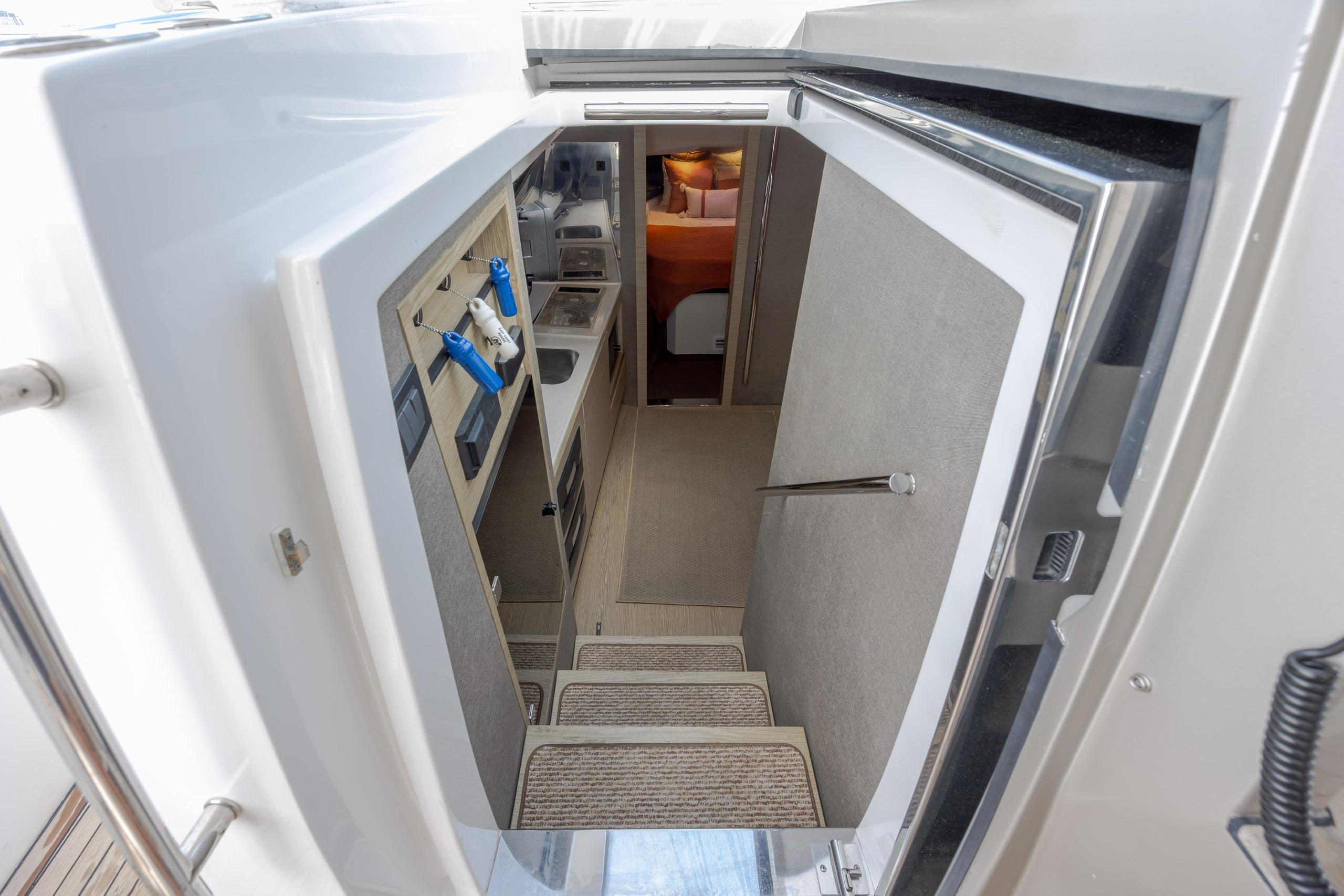 Interior view of 2019 Azimut Verve 40 yacht, featuring stairs and compact kitchen area.