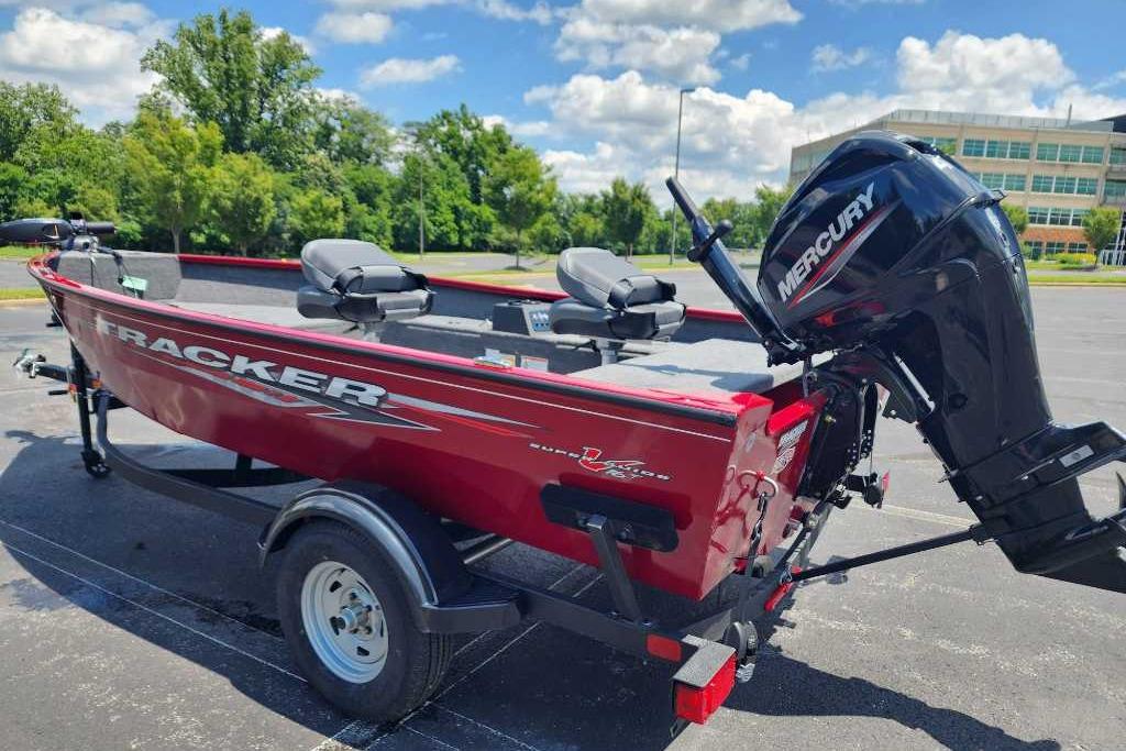 2025 Tracker Super Guide V-16 T boat with Mercury engine in parking lot.