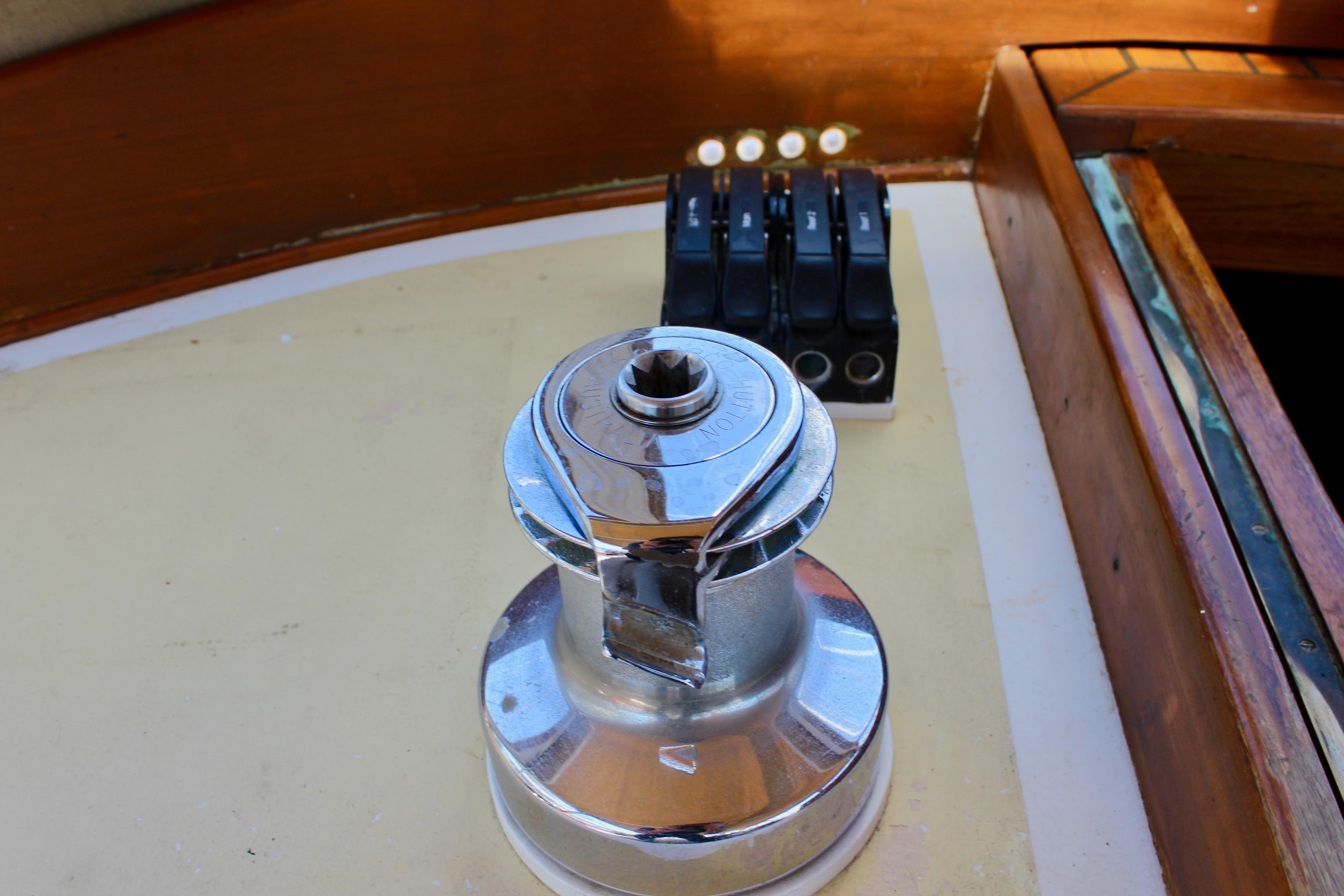 Winch on 1981 Kelly Peterson 46 sailboat deck, with control levers in background.