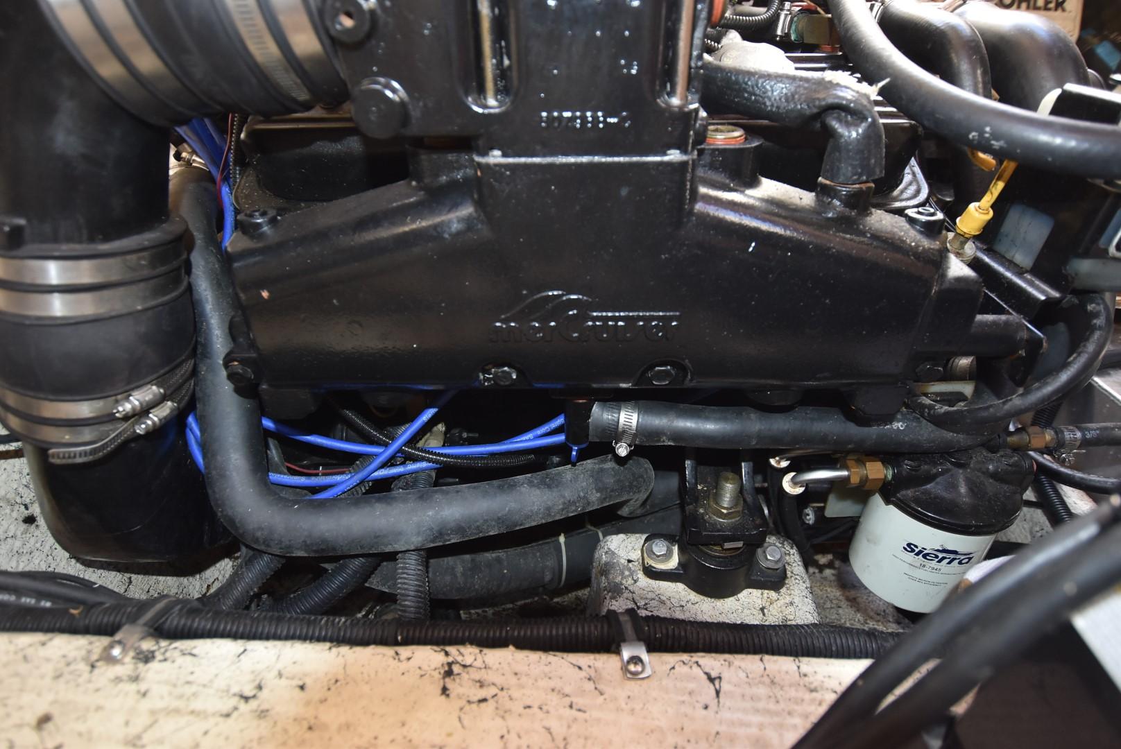Engine components of a 1999 Rinker 270 Fiesta Vee boat, featuring hoses and filters.