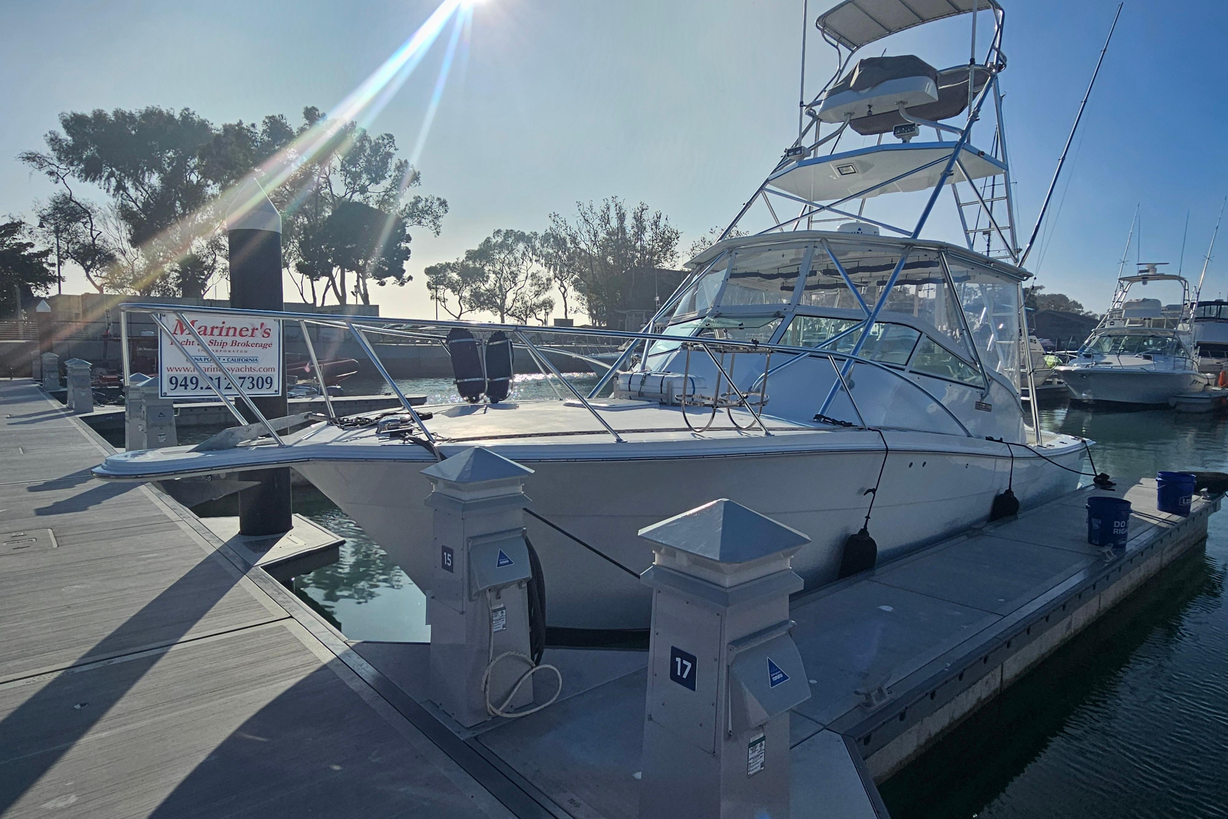 2003 Topaz 32 Express boat docked at marina under clear sky.