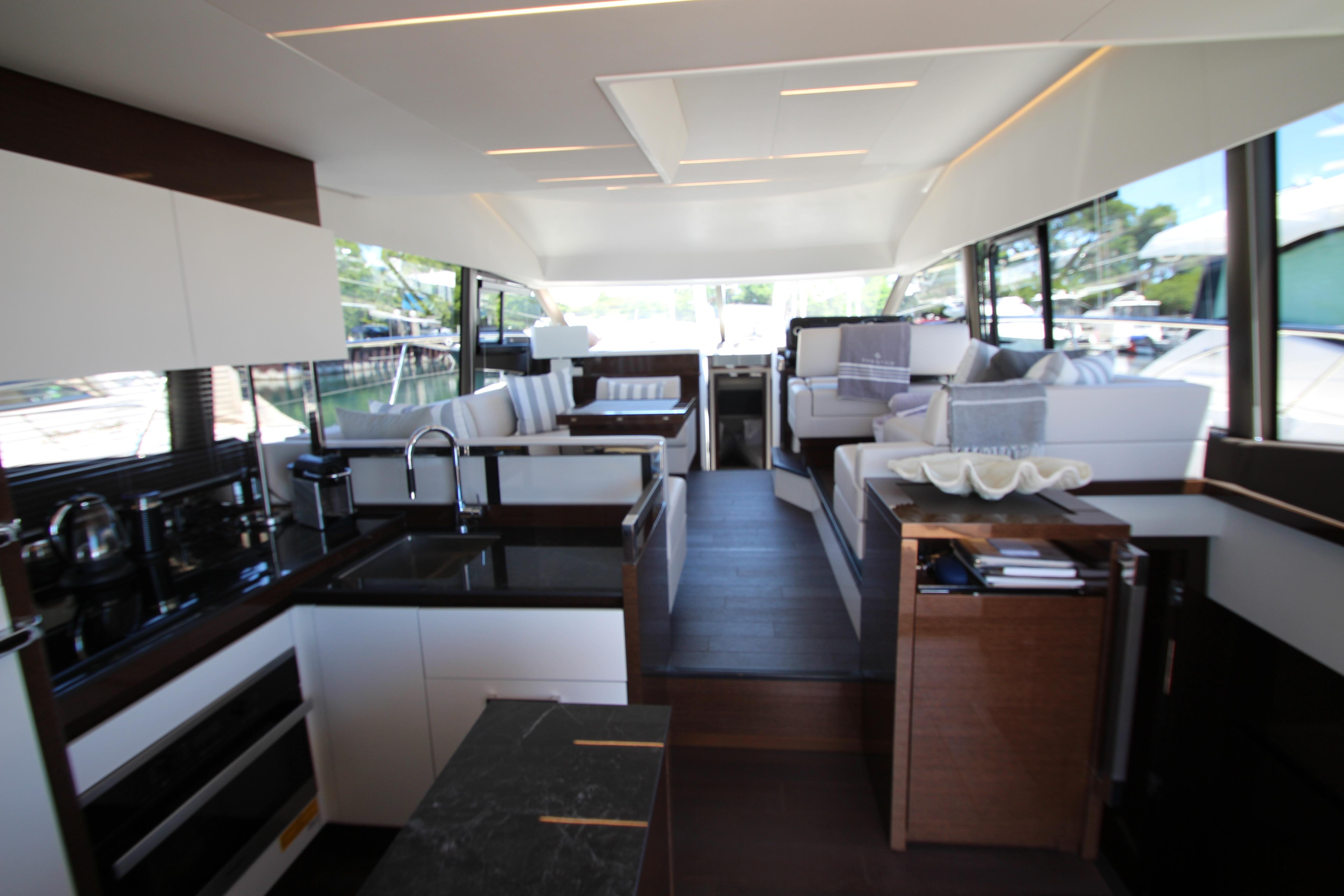 Luxurious interior of 2022 Prestige 520 yacht with modern kitchen and seating area.