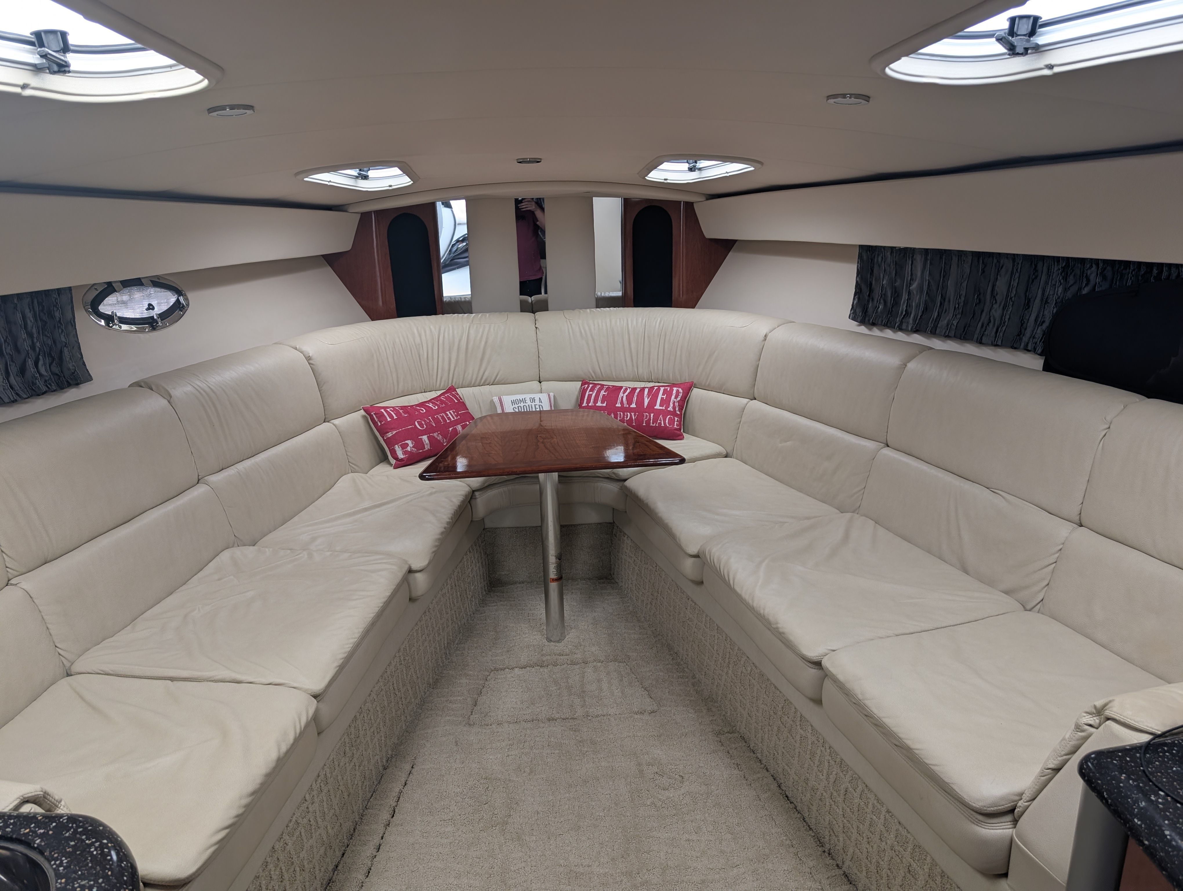 Interior of a 2007 Formula 400 Super Sport with beige leather sofas and a wooden table.