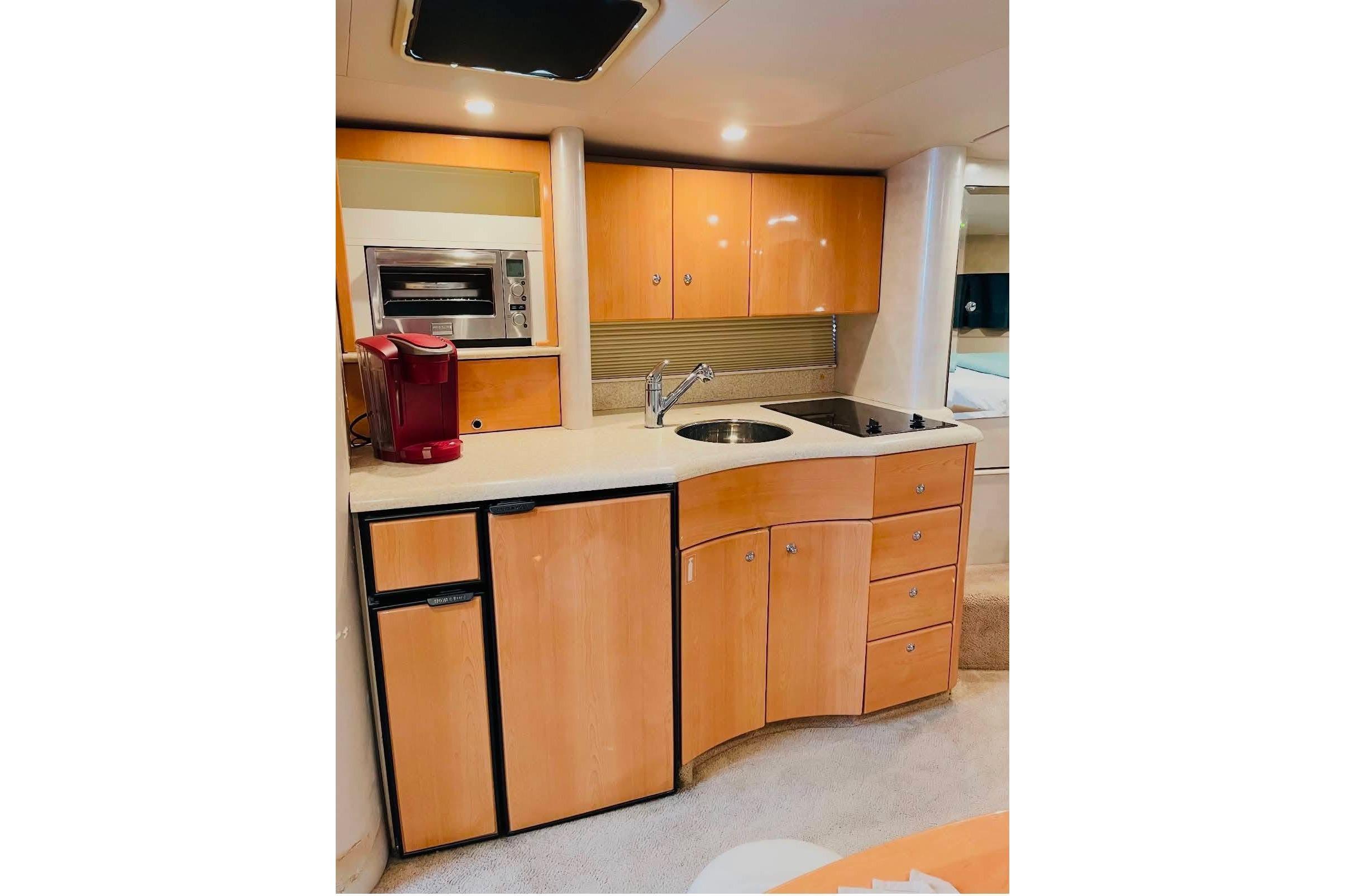 2003 Formula 40 Performance Cruiser kitchen with modern appliances and wooden cabinetry.