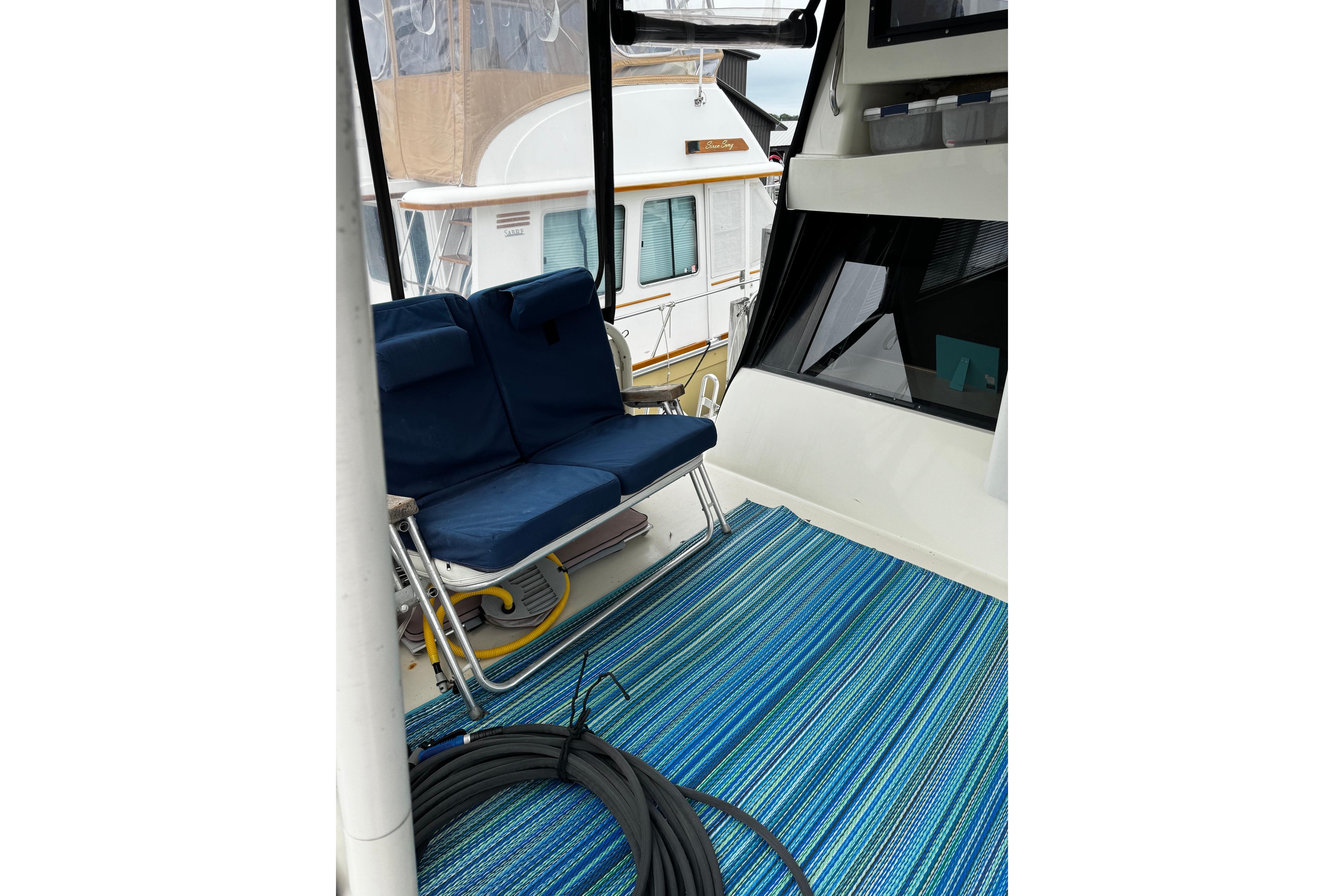 Interior view of 1991 Silverton 46 Motor Yacht with blue seating and striped carpet.