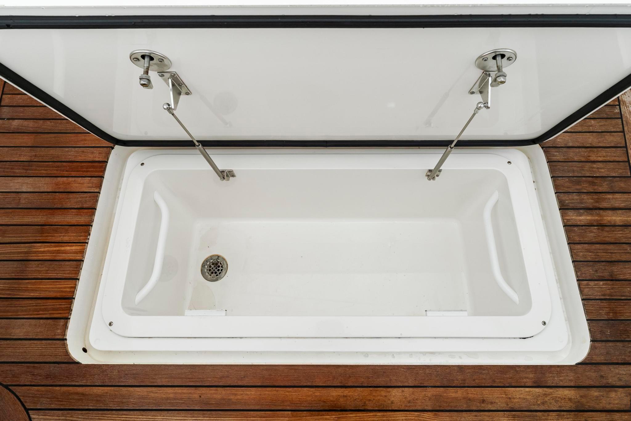 Open storage compartment on 2018 Viking 44 Express boat with wooden deck.