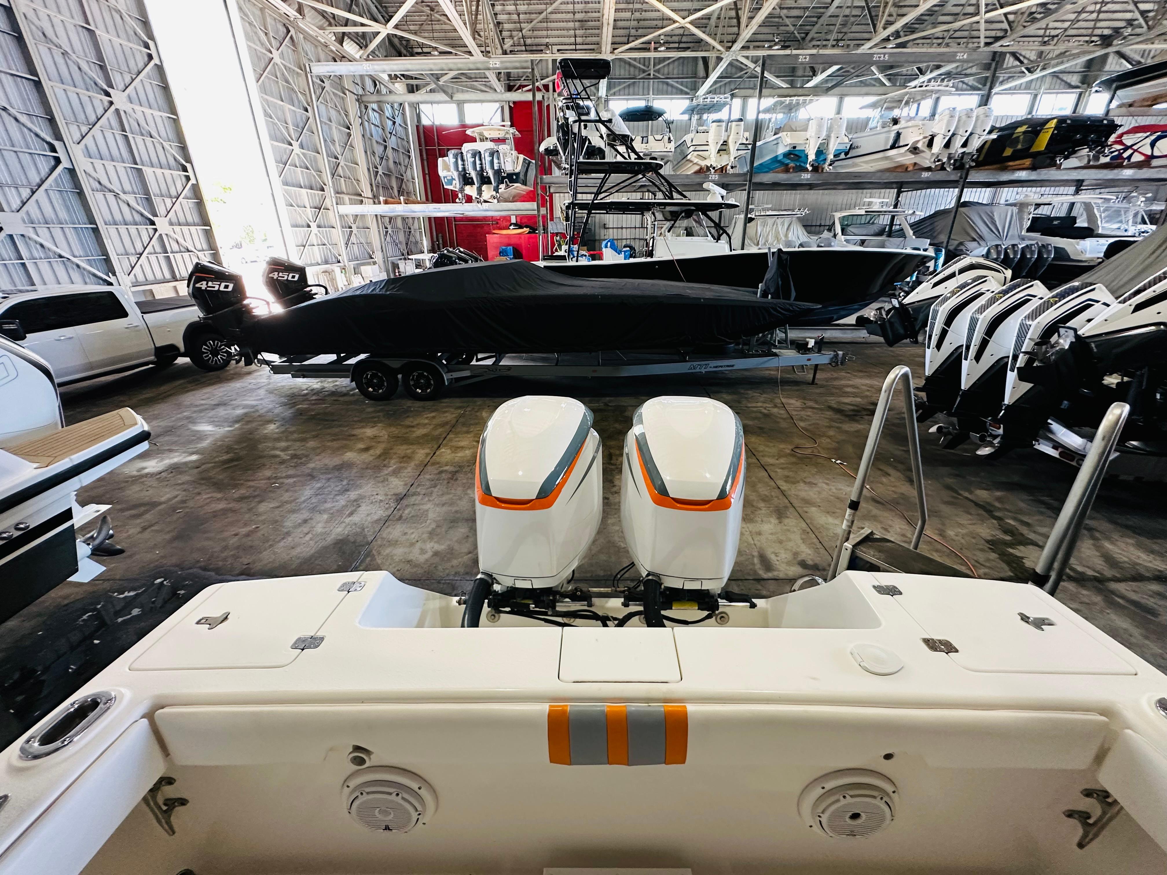 2003 Intrepid 322 Cuddy boat in storage with dual outboard engines.