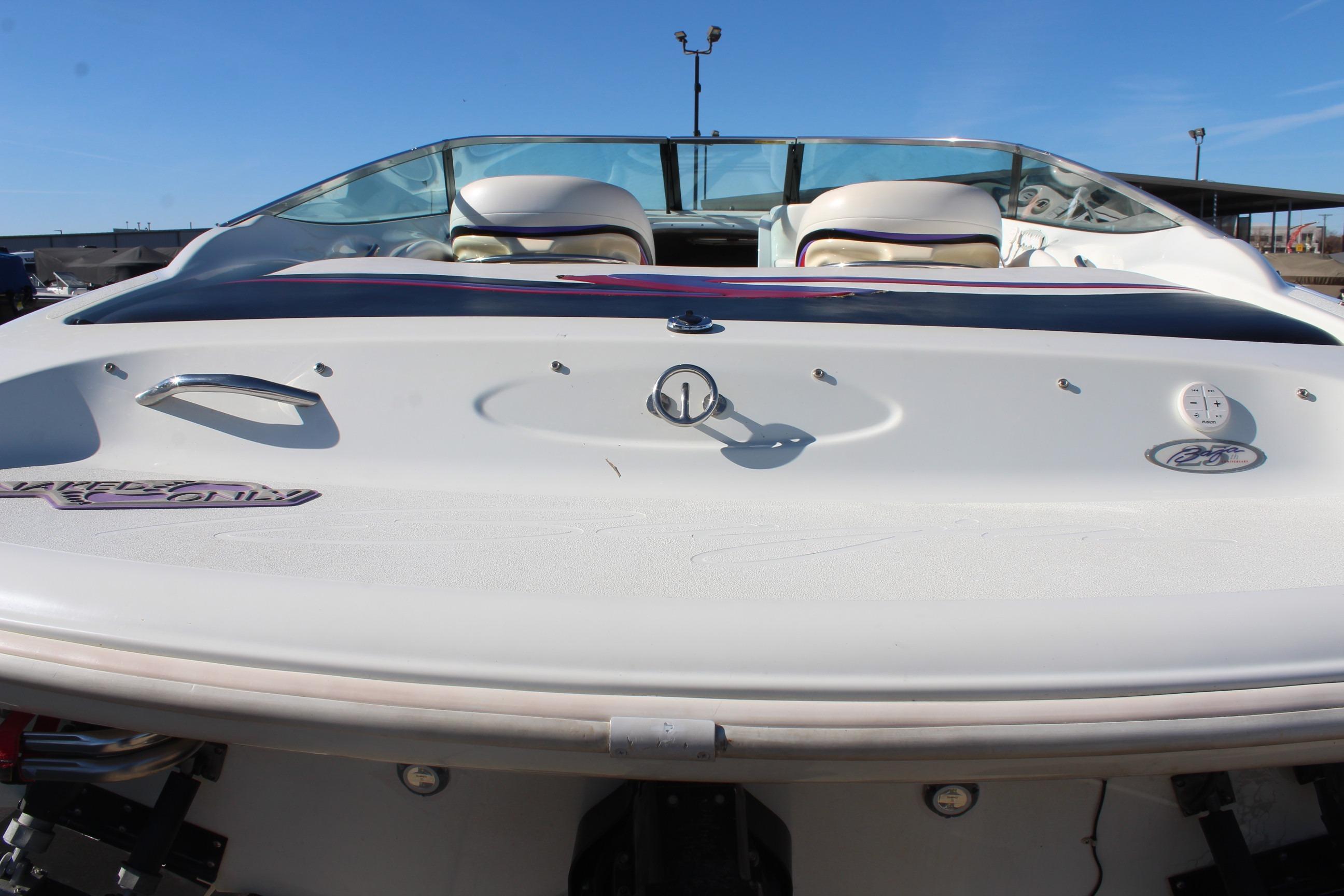 1996 Baja 232 boat rear view, showcasing sleek design and seating under clear blue sky.