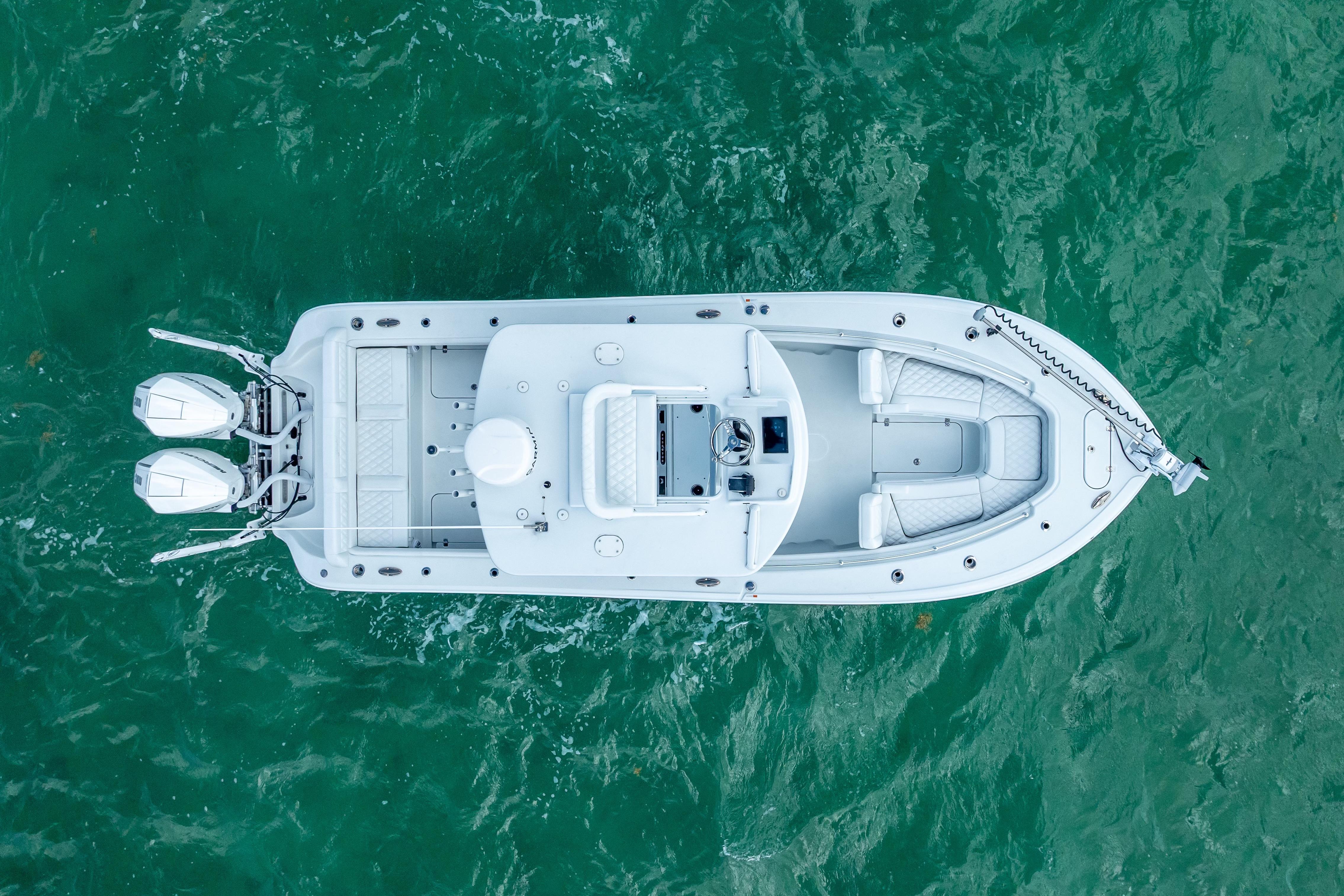 Aerial view of 2026 Yellowfin 26 Hybrid boat on turquoise water.