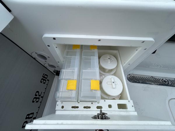 Storage compartment on a 2024 Sea Pro 250 DLX boat with organized containers.