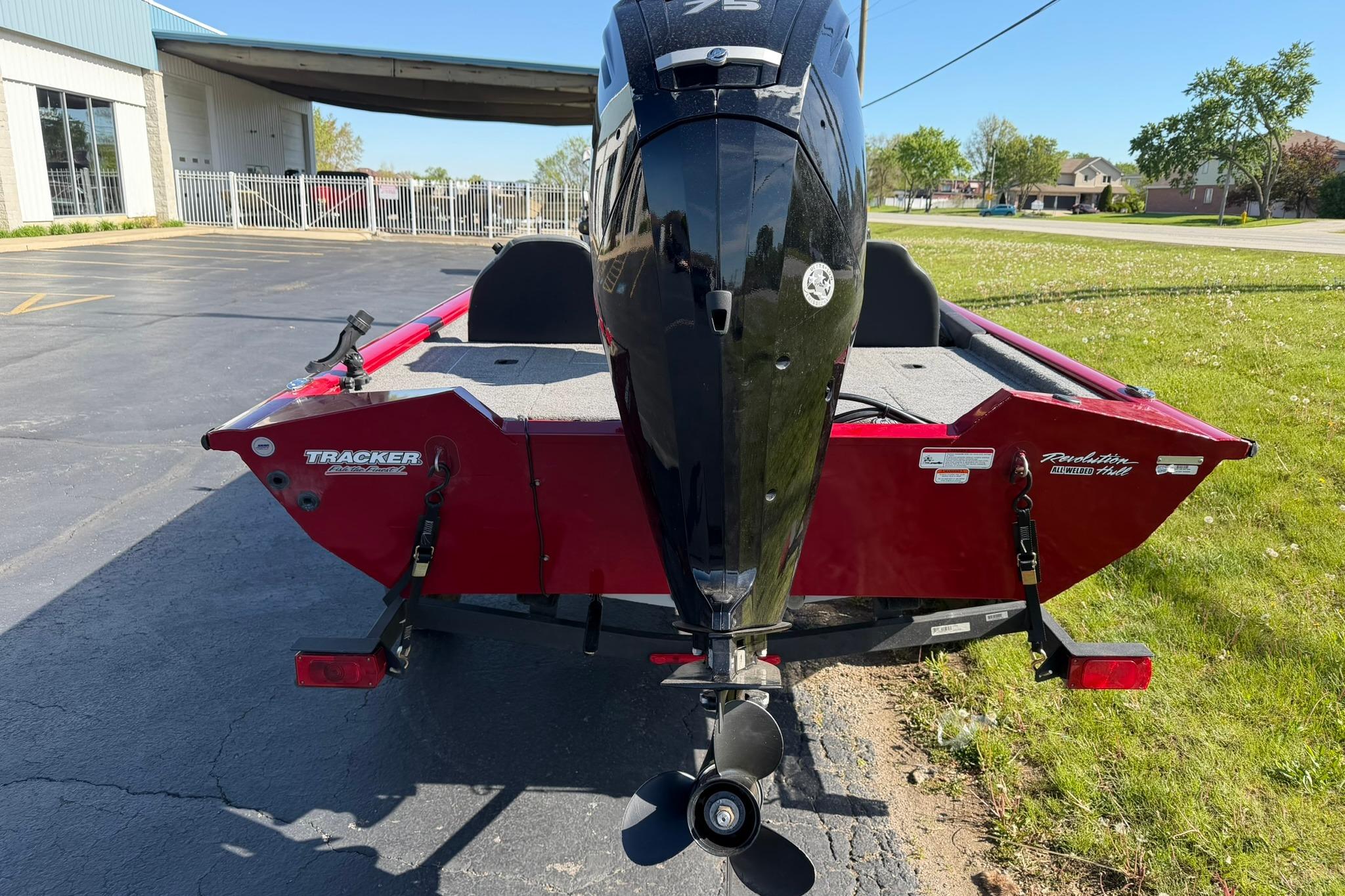 2024 Tracker Pro Team 175 TXW boat, rear view with motor, parked outdoors.