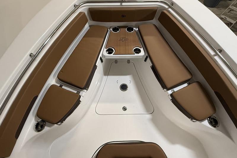 2026 Sea Pro 242 Center Console boat interior with brown cushioned seating and cup holders.
