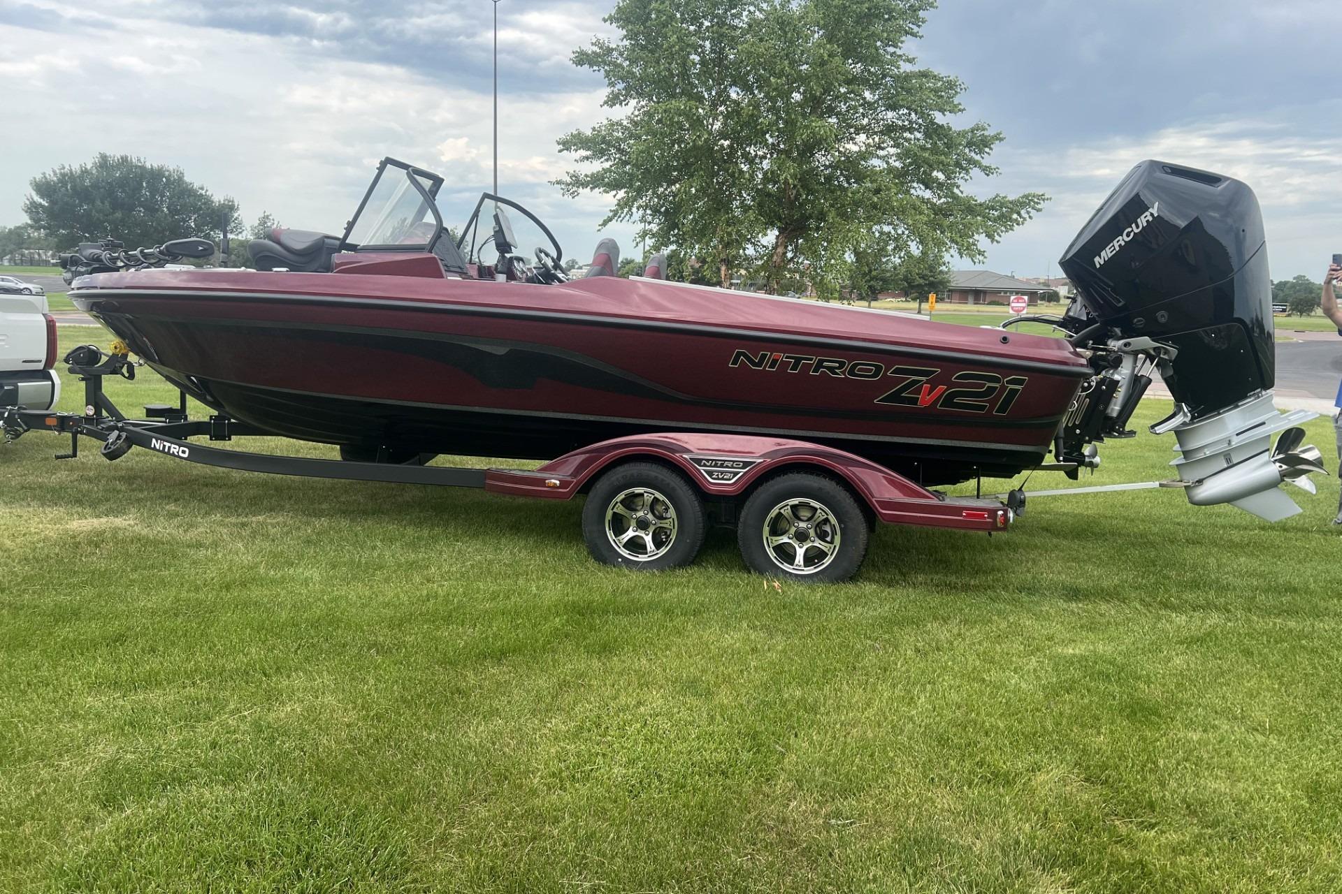 2026 Nitro ZV21 Pro boat on trailer, parked on grass, with Mercury outboard motor.