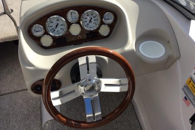 Steering wheel and dashboard of 2012 Glastron GT180 boat with gauges.