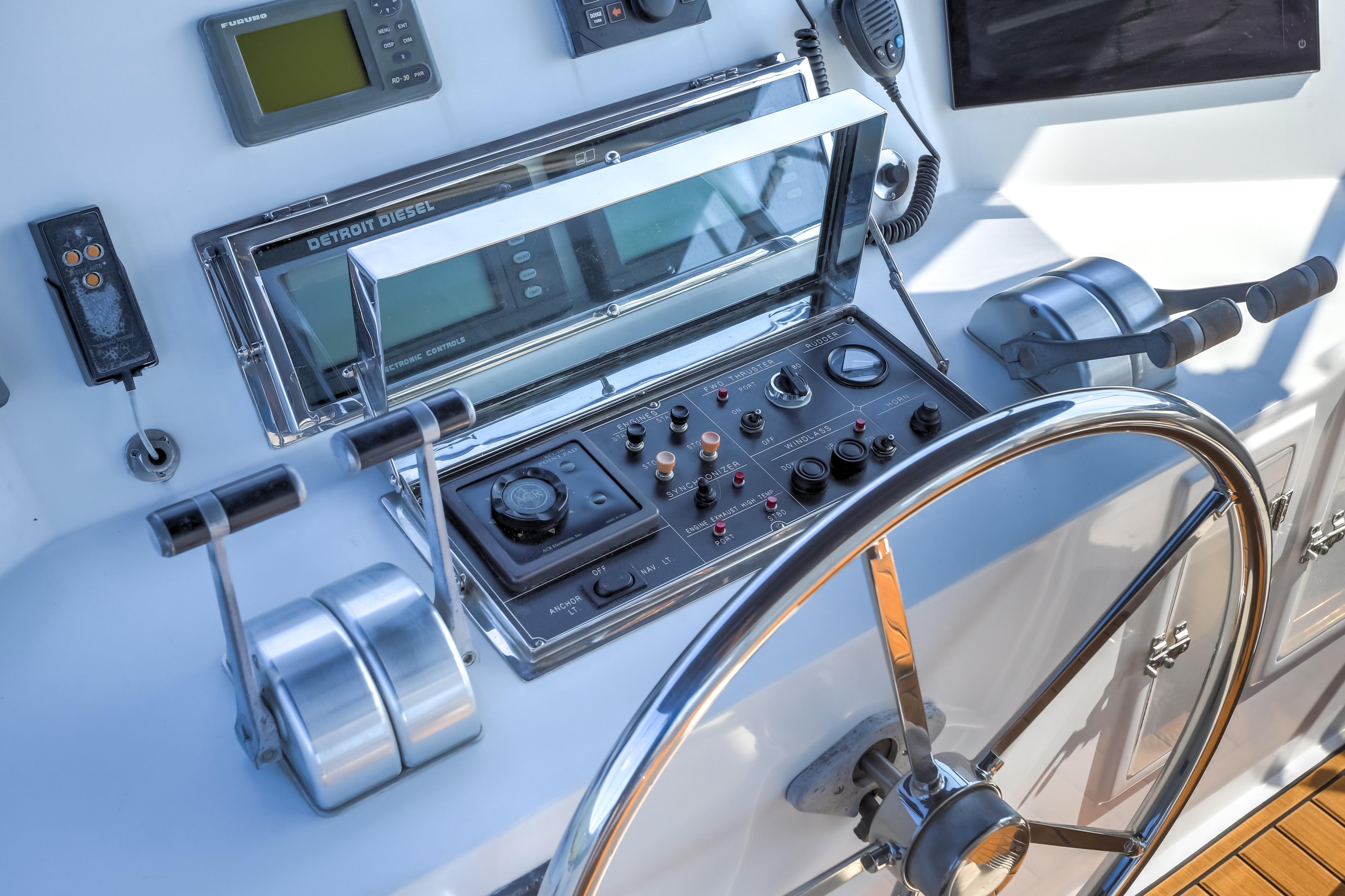 Control panel of a 2003 Jefferson Pilothouse 57 yacht with steering wheel and navigation instruments.