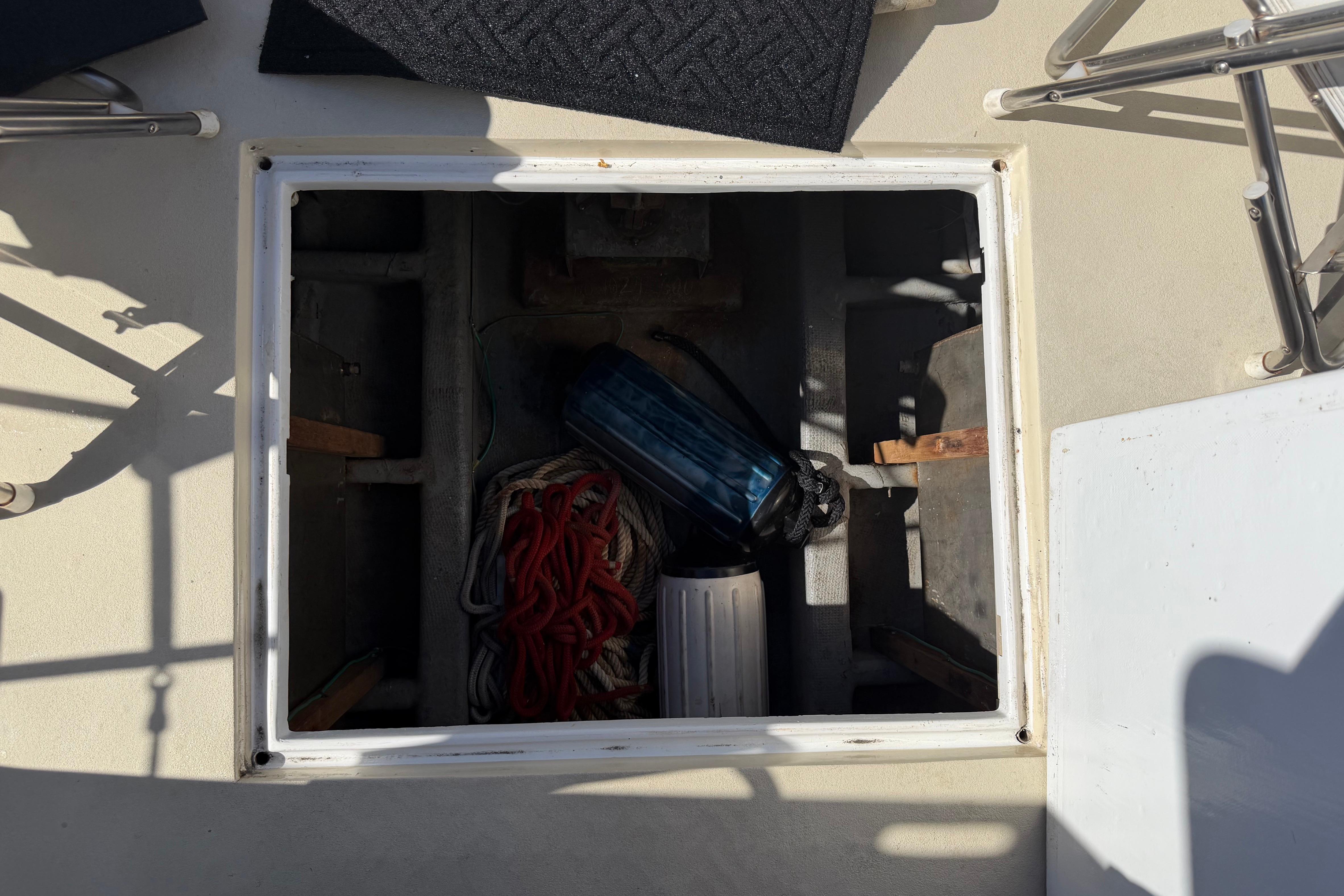 Open hatch on 1982 Lien Hwa 31 boat, showing storage with ropes and equipment.
