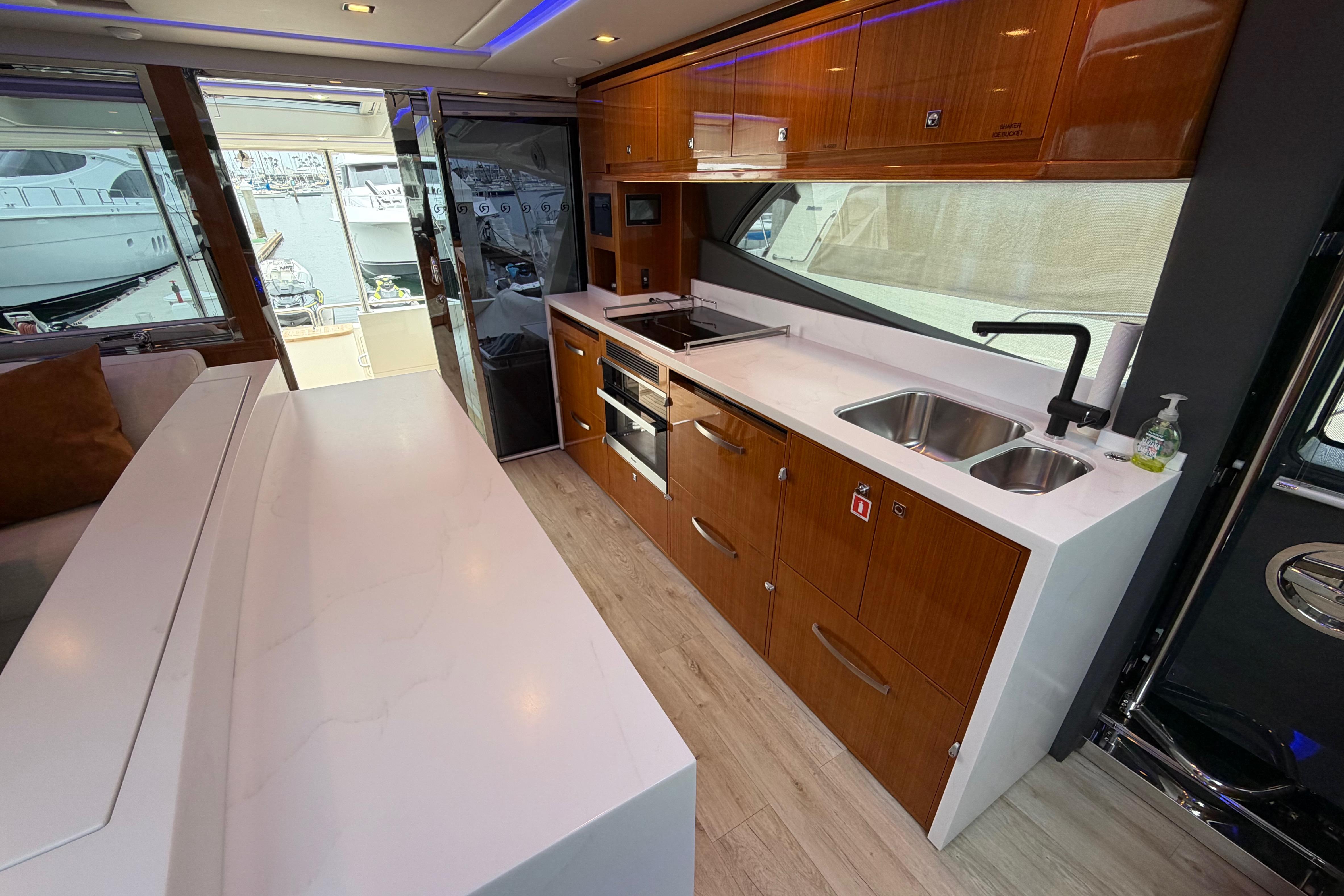 Luxurious kitchen interior of 2023 Riviera 645 SUV yacht with modern amenities.