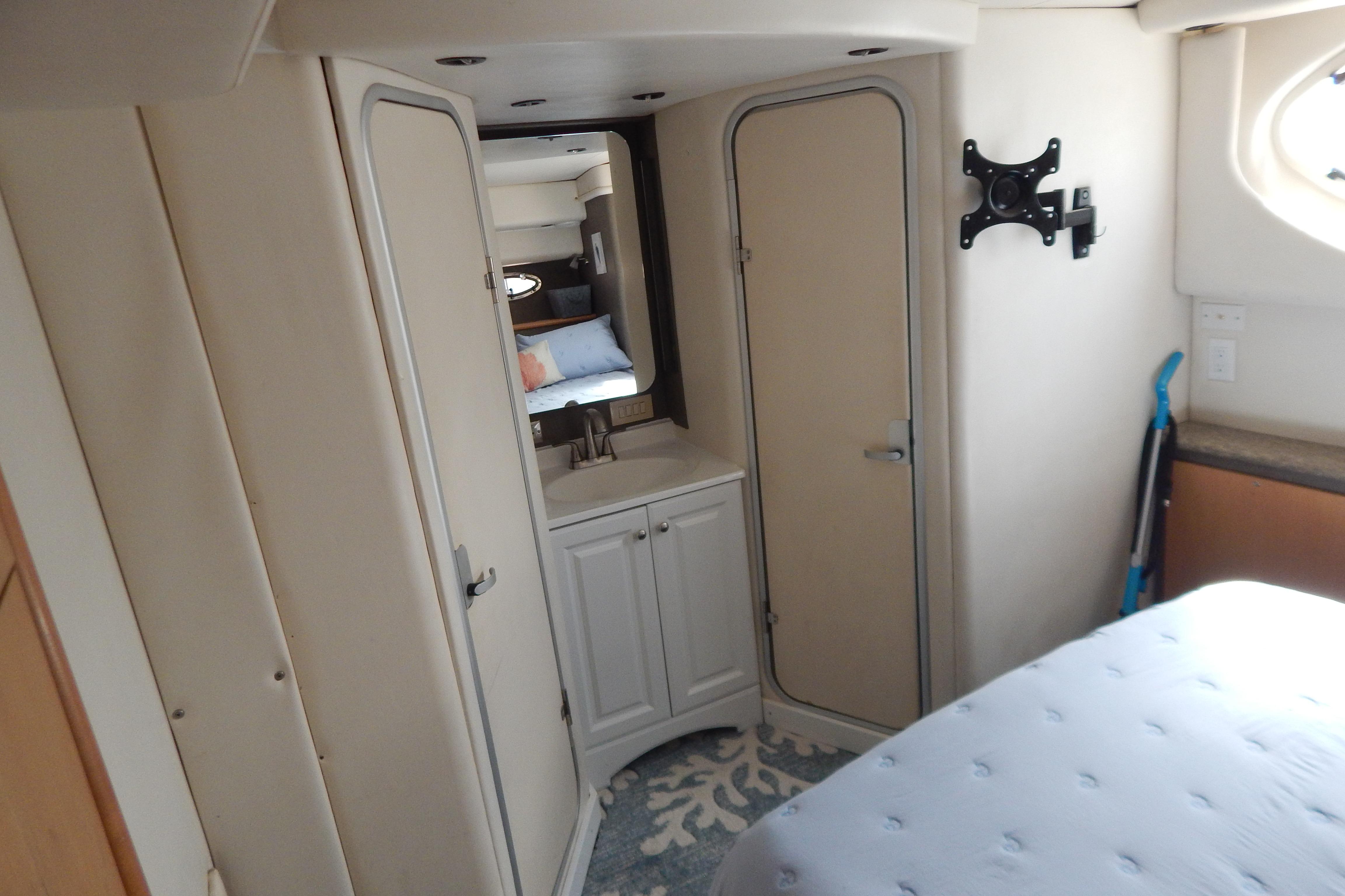 Interior of 1998 Magnum 4100 SCR yacht with bed, cabinets, and wall-mounted TV bracket.