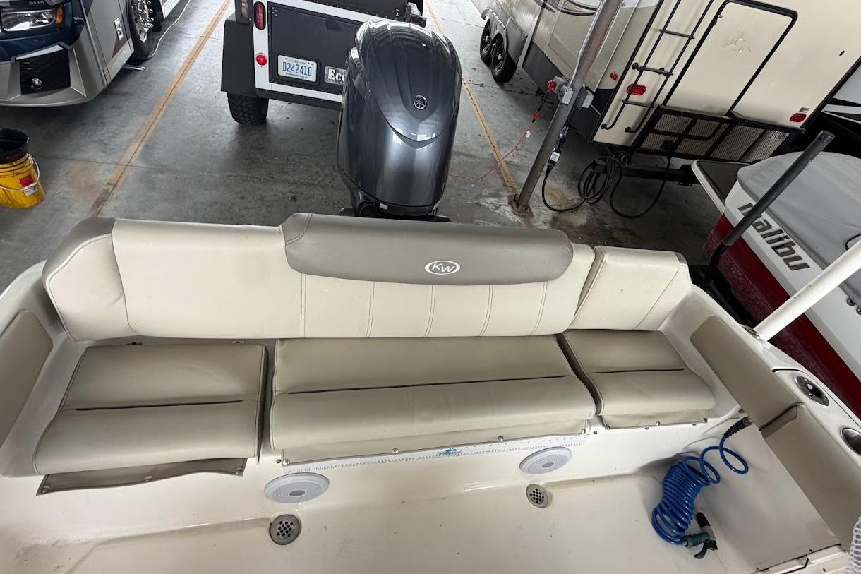 2024 Key West 219 FS boat interior with beige seating and motor in storage.