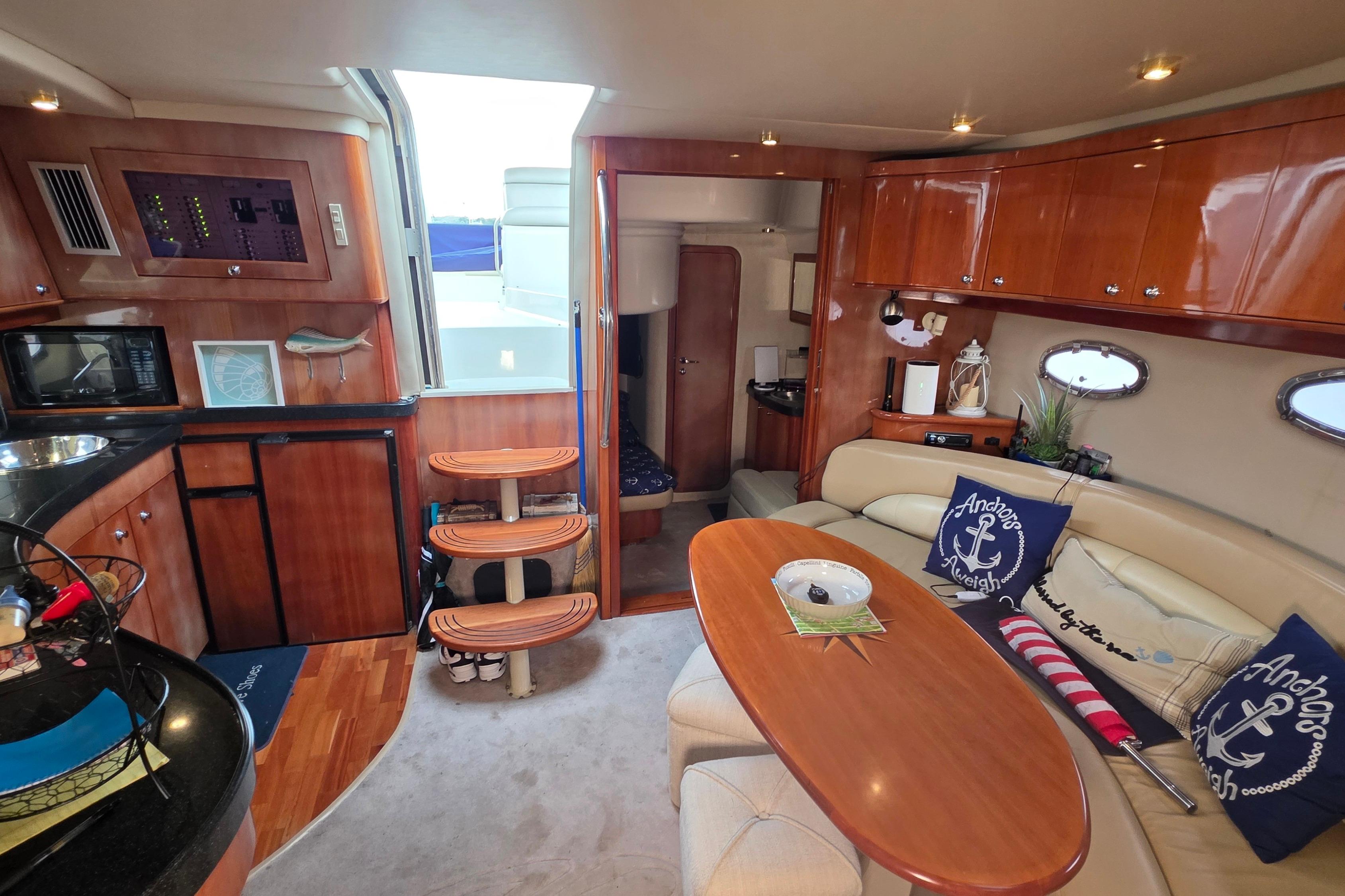 Luxurious interior of 2002 Regal Commodore 4260 yacht with elegant wood finishes and cozy seating.