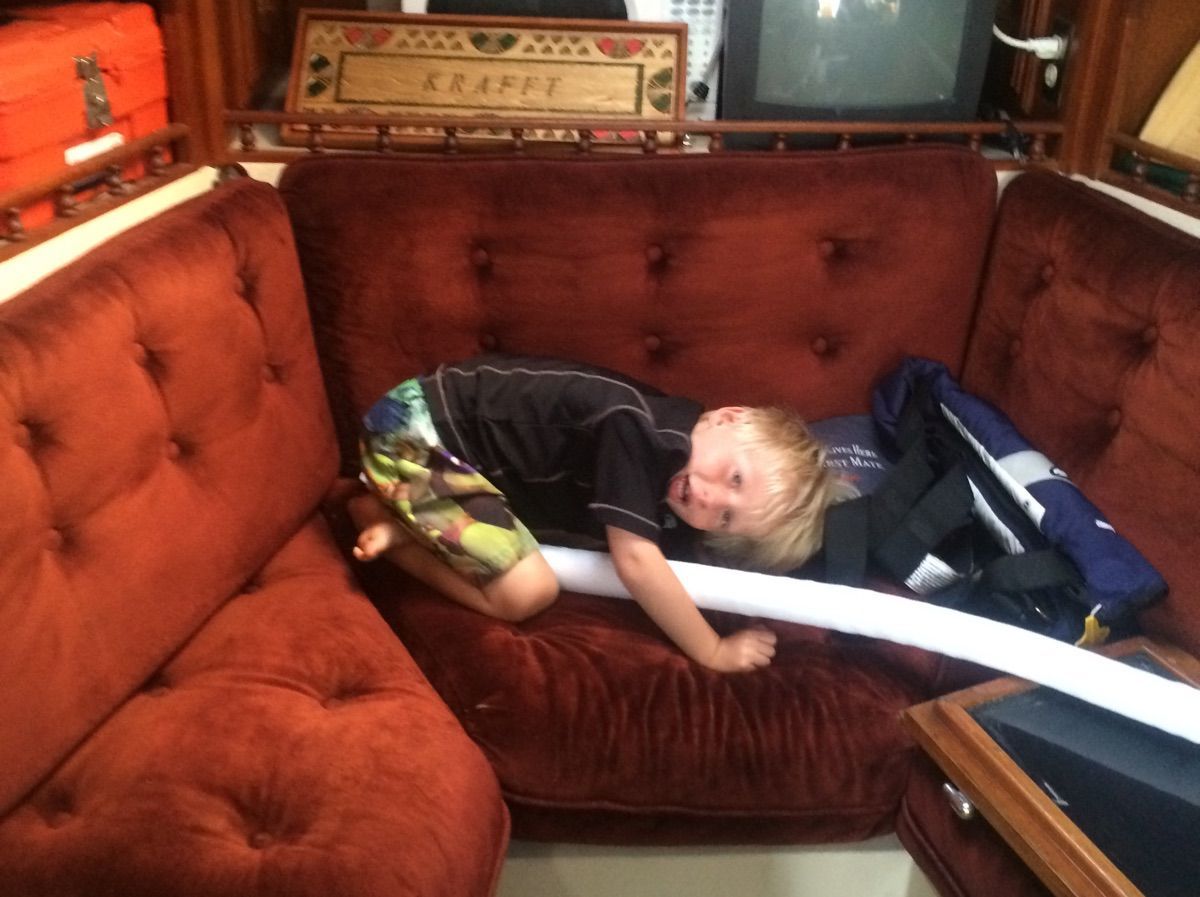 Child on red sofa in a Lancer Sloop 36 yacht.
