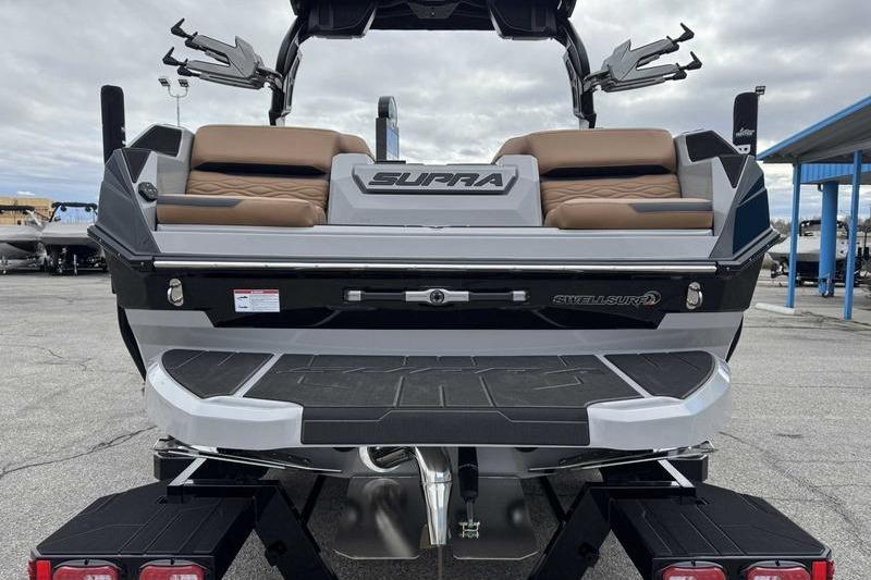2026 Supra SA boat rear view with tan seating and Swell Surf system.