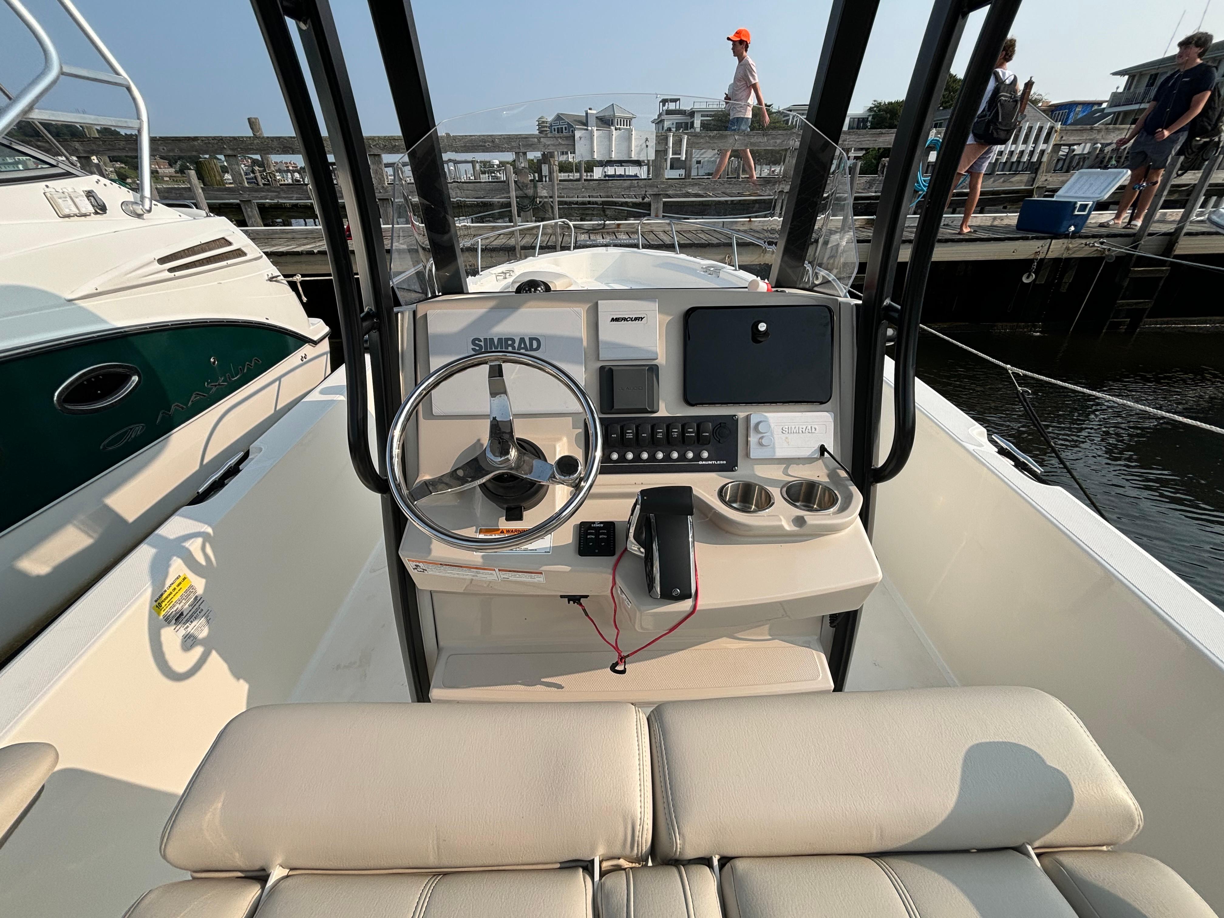 2023 Boston Whaler 250 Dauntless boat cockpit with steering wheel and navigation equipment.