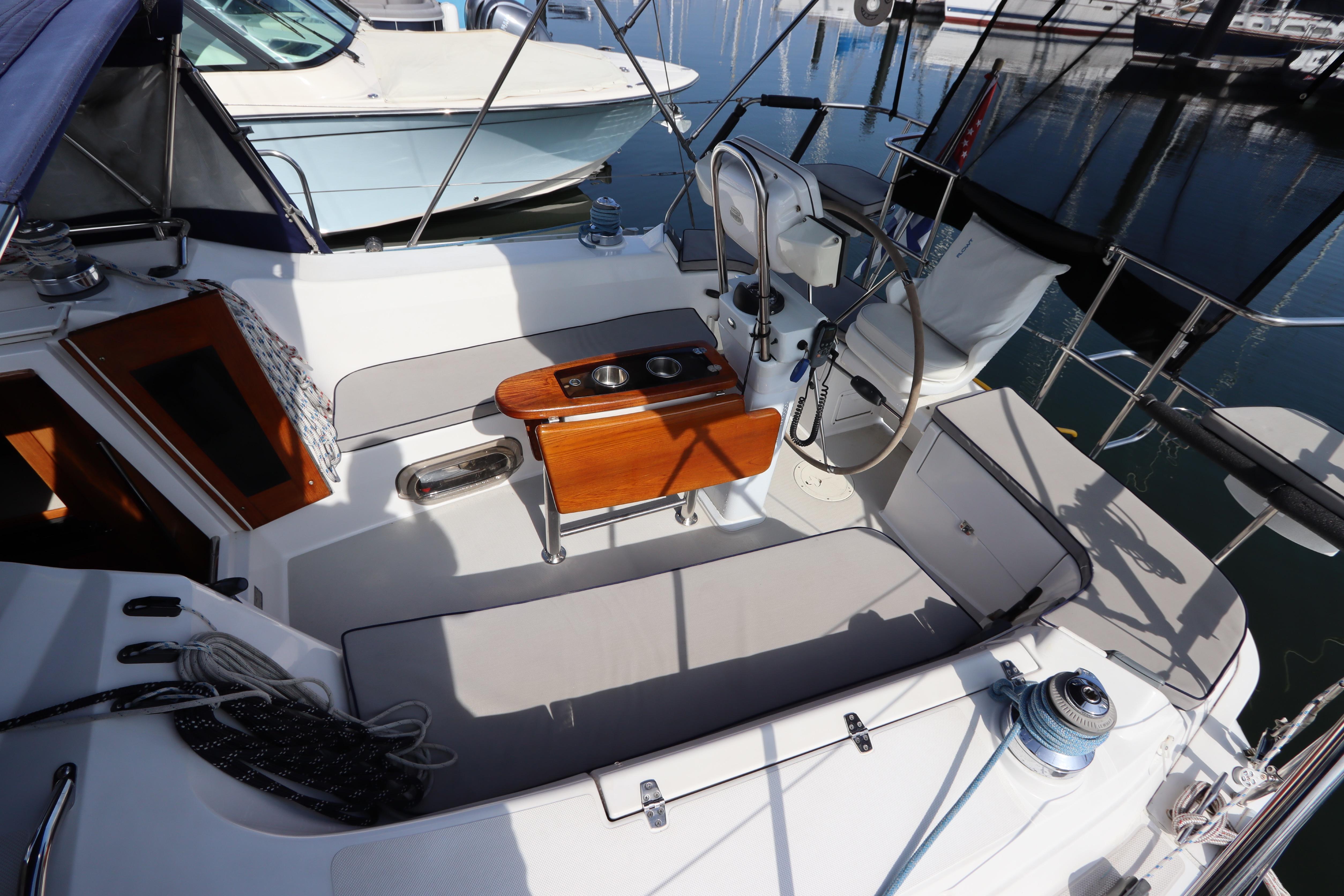 Cockpit of 2011 Catalina 355 sailboat with seating and steering wheel in marina.