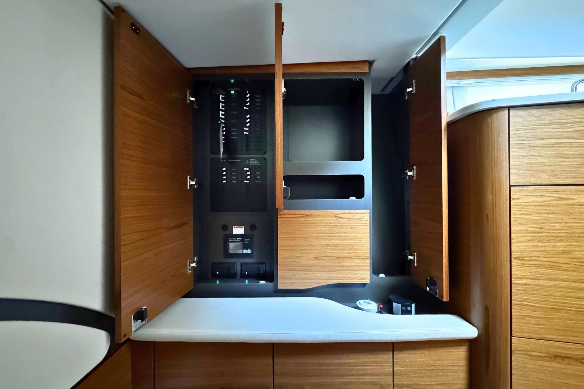 2027 Tiara Yachts 39 LE interior with open wooden cabinets and control panel.
