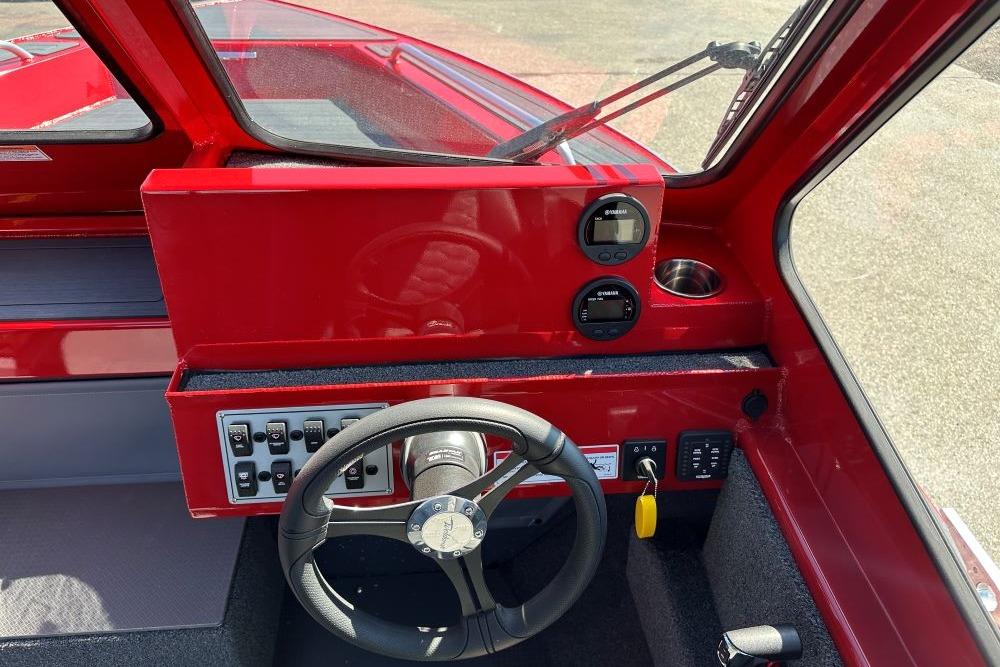 Interior view of 2026 Weldcraft 240 Maverick DV boat dashboard with steering wheel and controls.